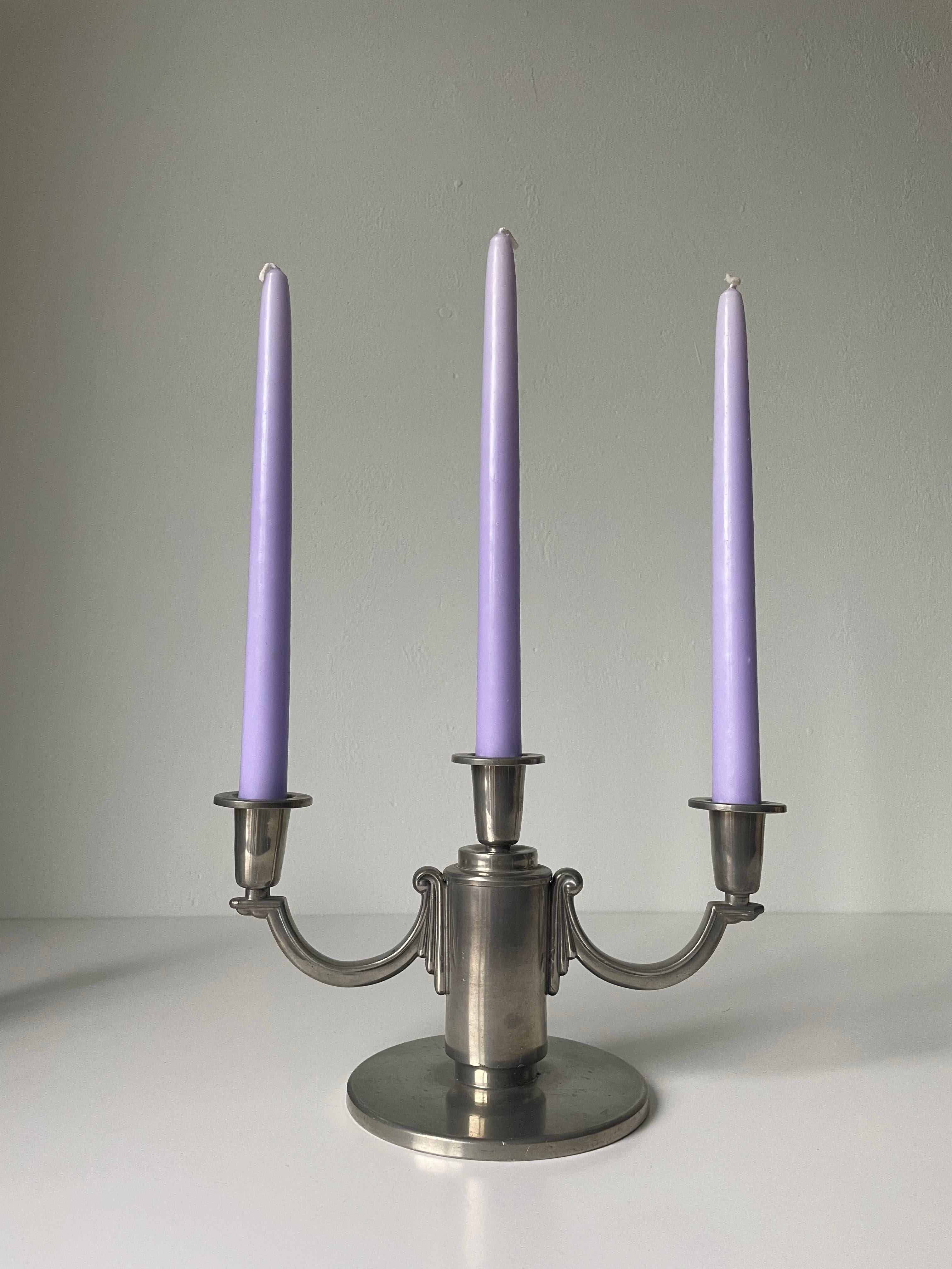 Paire de candélabres en étain et en argent de style Arte Antiques, conçus et fabriqués à la main par Lundin & Lindberg dans les années 1930. Les deux sont estampillés I.L.A. sous la base et sont en très bon état. L'un d'entre eux présente une