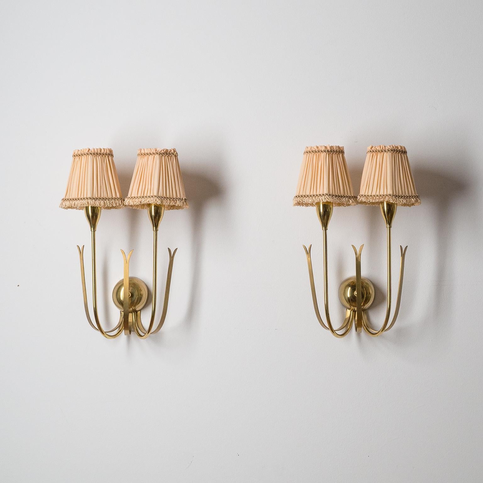 Pair of two-arm brass wall lights, late 1940s. Fine modernist design with a light Art Deco touch. The stems and the backplate cover are polished brass, while the three decorative elements have a brushed finish. Good original condition with light