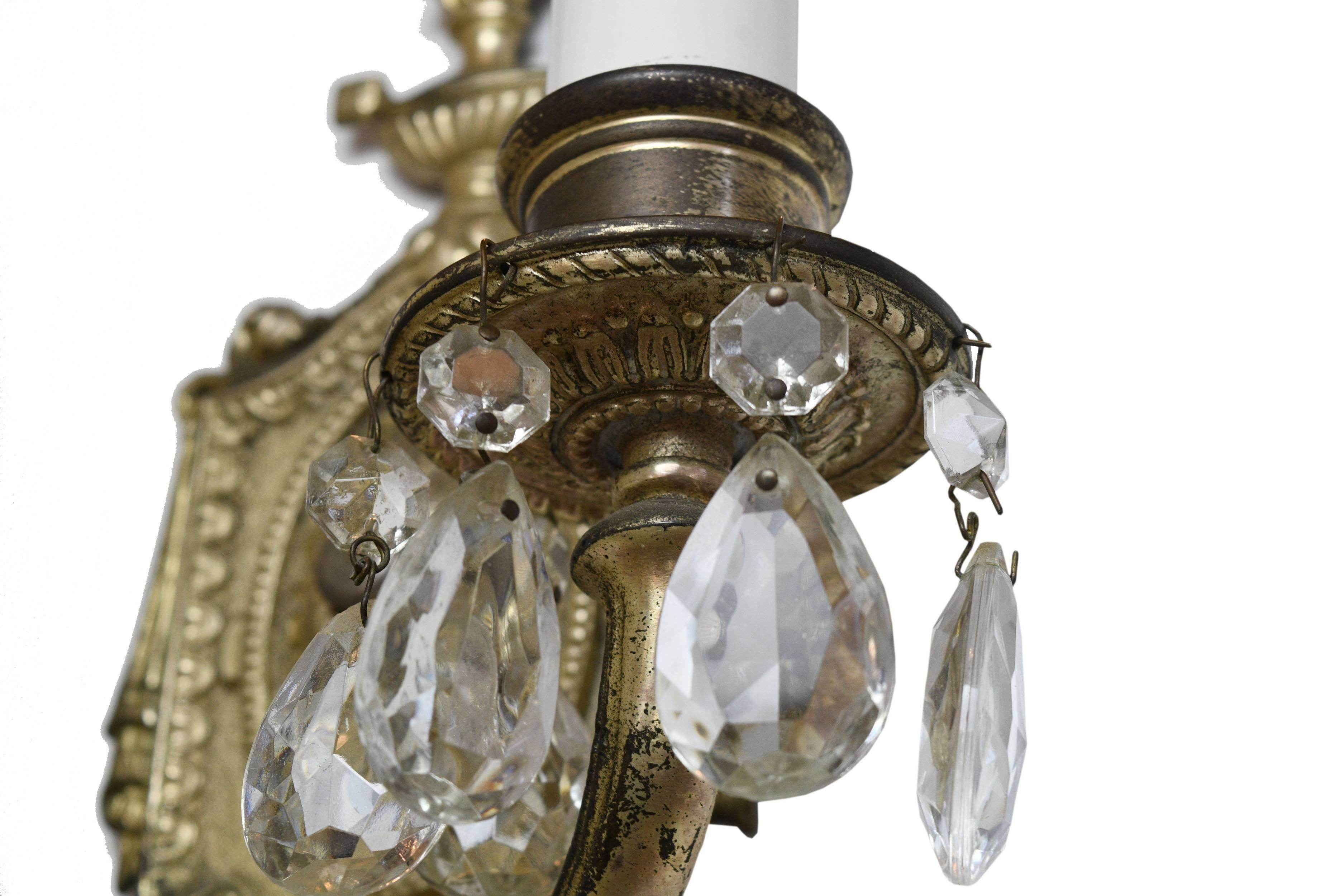This two-arm silver over brass sconce features teardrop crystals on both arms and elegant detailing throughout. Perfect for adding that elegant, formal touch to any space. 

Measures: 12.75
