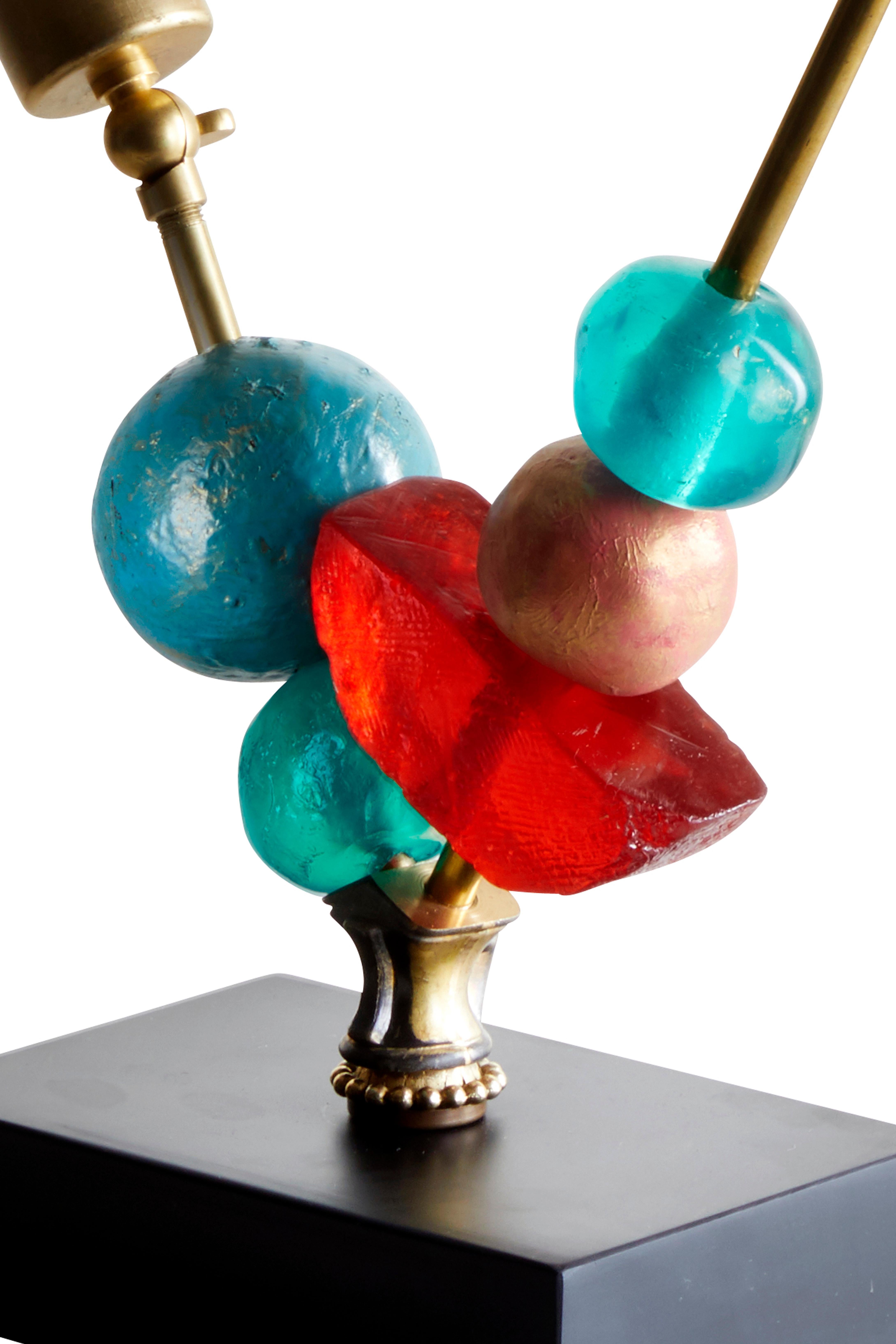 This Margit Wittig lamp can serve as a table lamp or as a desk and art light. With translucent epoxy resin emerald and fire red elements this piece is made in Wittig's London studio.

Margit Wittig is inspired by modern artists and sculptors such as