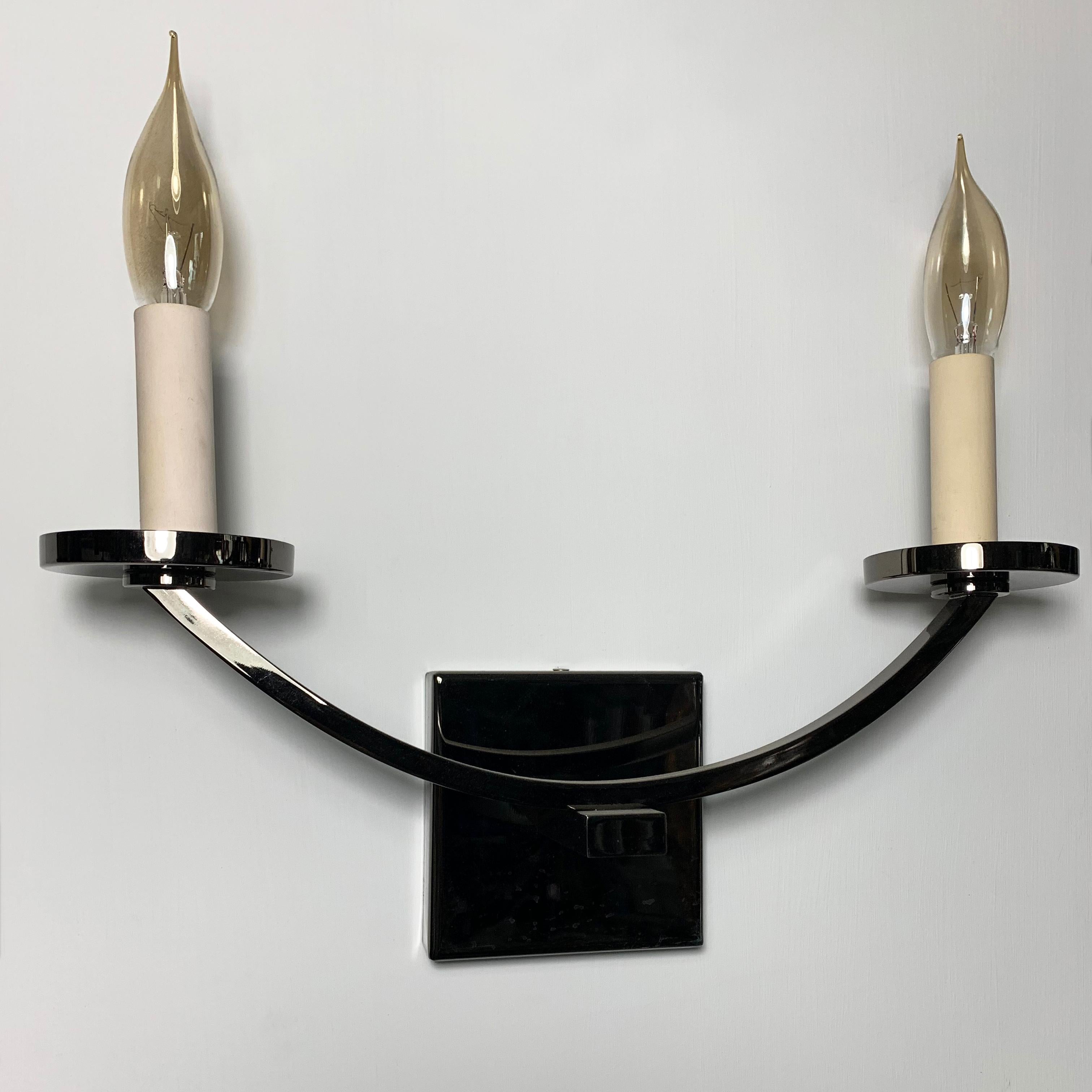 Original prototype.
Contemporary two-arm brass wall light with dark nickel plating.
Shown here with blue colored card-candles.
Also available, a rustic bronze version and a painted version.
Made in Italy.