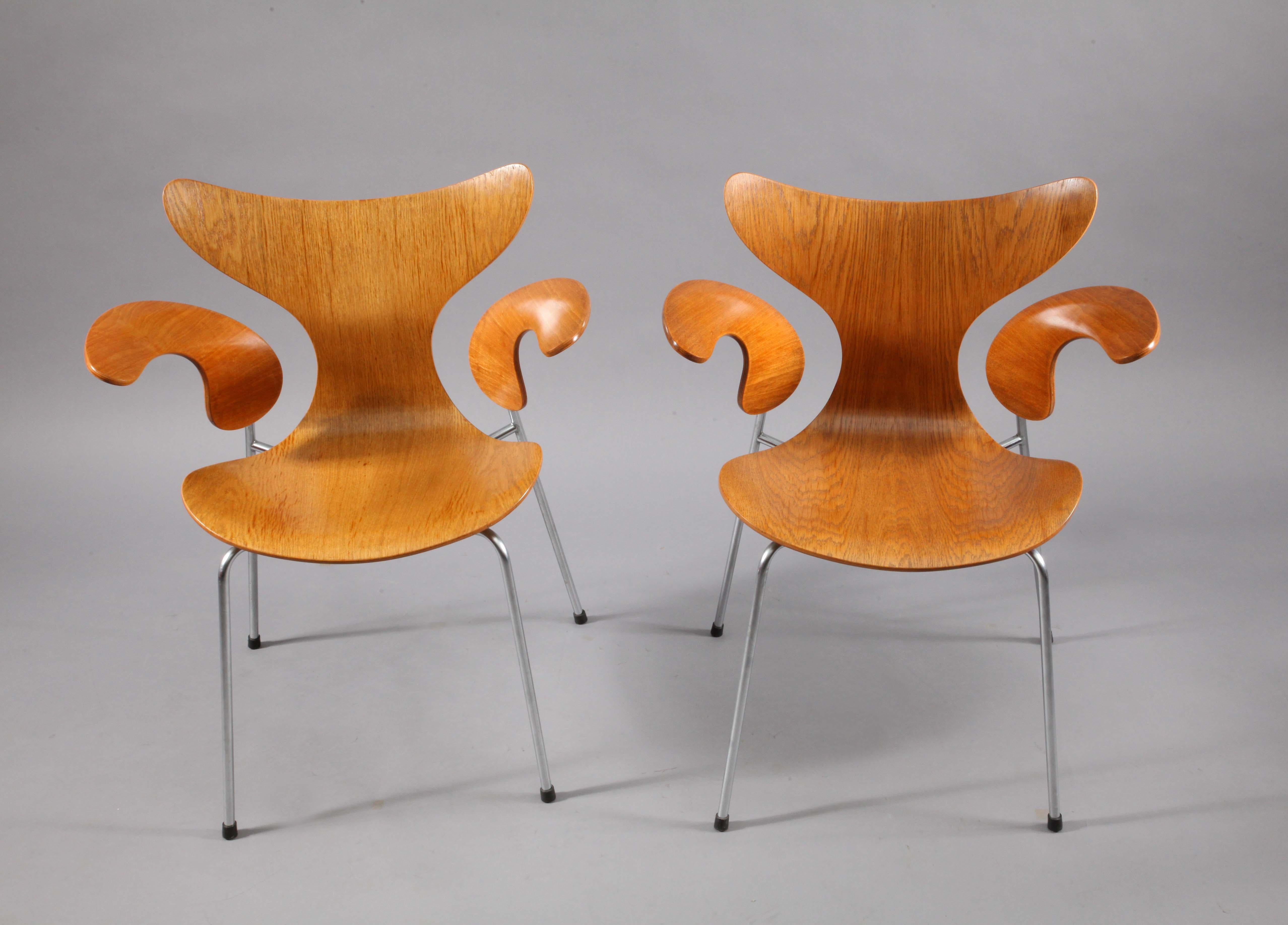 Two armchairs with oak shell and armrests, chromed tubular steel base. 
Designed in 1970. Arne Jacobsen, Produced by Fritz Hansen, year 1970.model 3208.
height 86cm, depht 54cm, widht 46cm