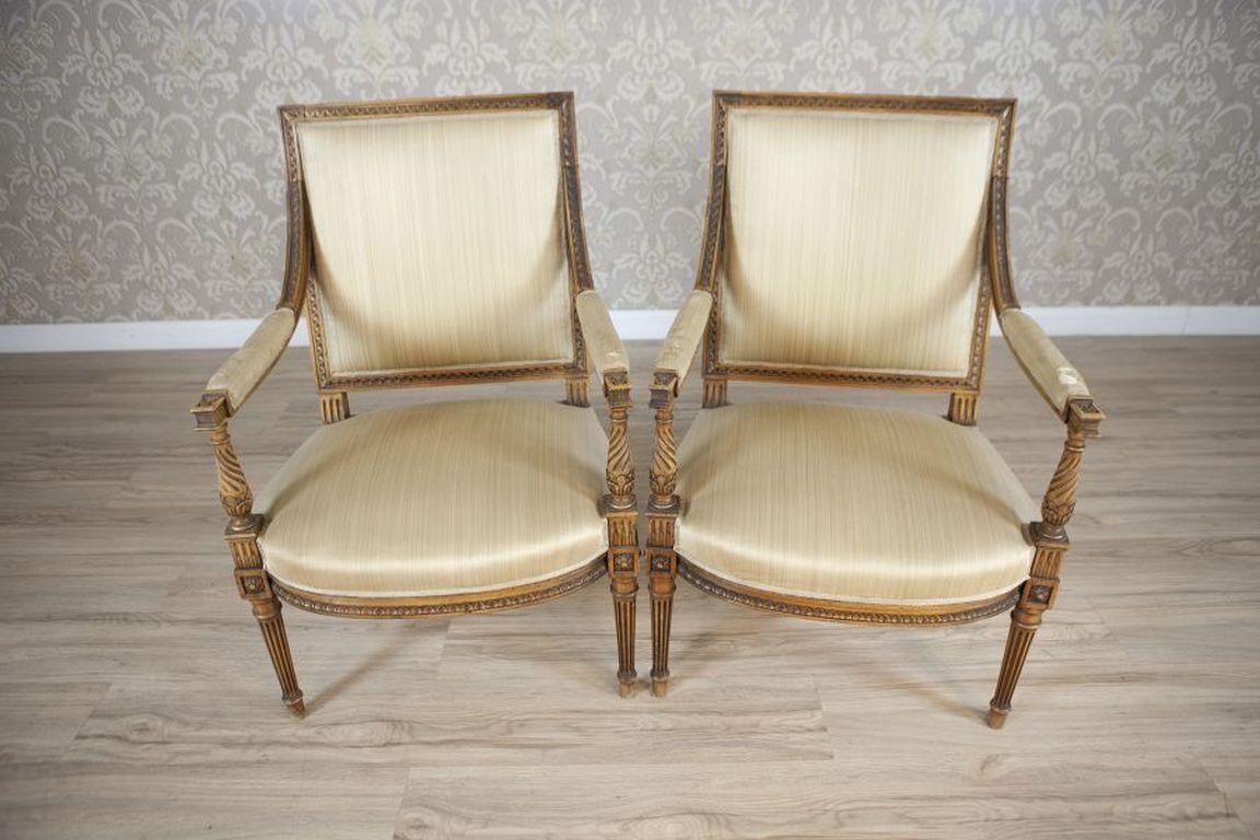 Two Louis XVI Salon Armchairs Circa 1930

Armchairs from the 1930s in the style of Louis XVI. Wooden frames adorned with rich carving. Seats on springs, upholstered like the backs and parts of the armrests. Simple fluted legs topped with a rosette