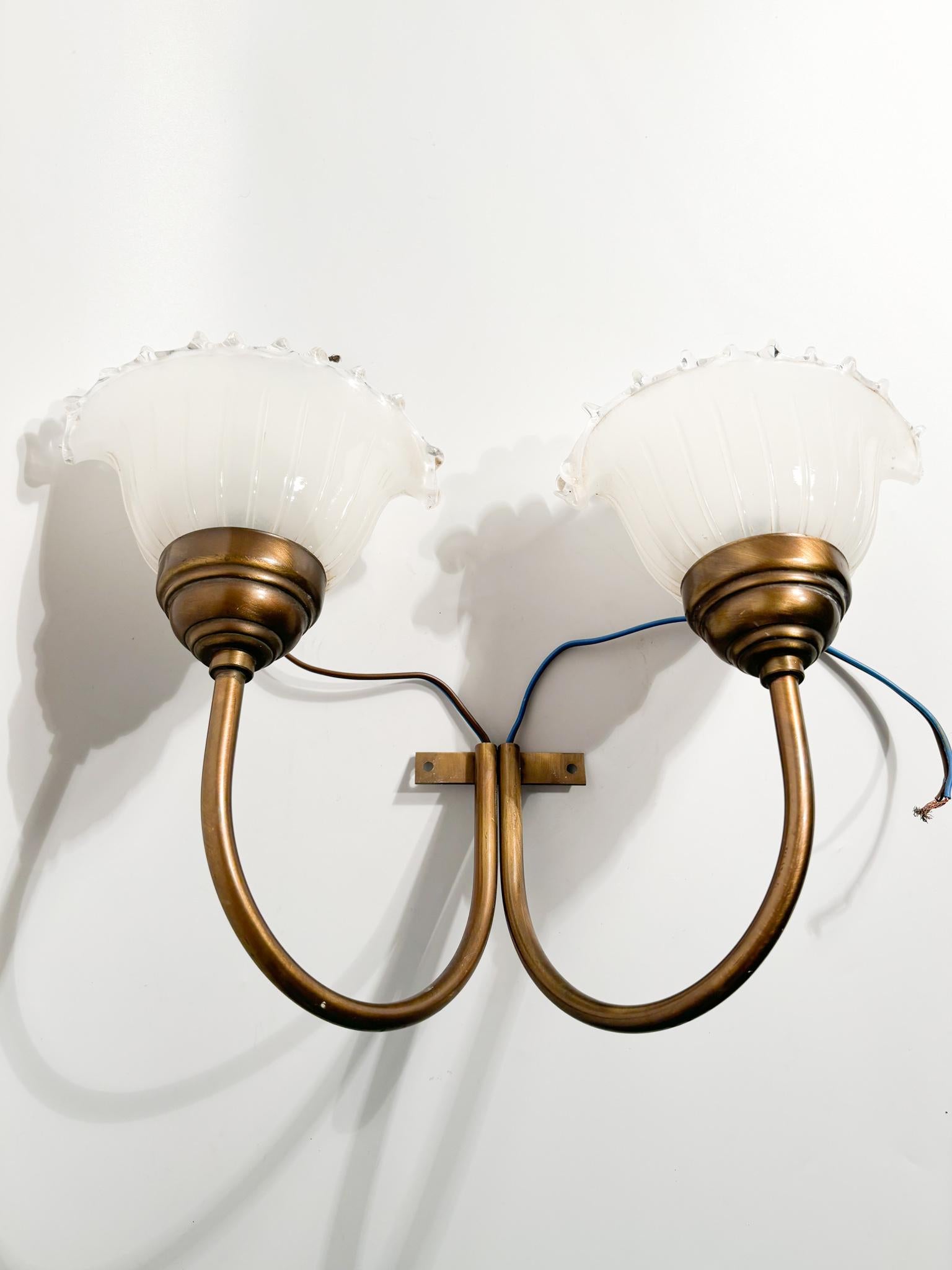 Two-light wall sconces in hand-blown Murano glass and brass, made in the 1940s

Ø cm 36 Ø cm 10 h cm 24

Murano glass is a type of artistic glass produced on the island of Murano, near Venice, Italy. It is known for its beauty, quality and