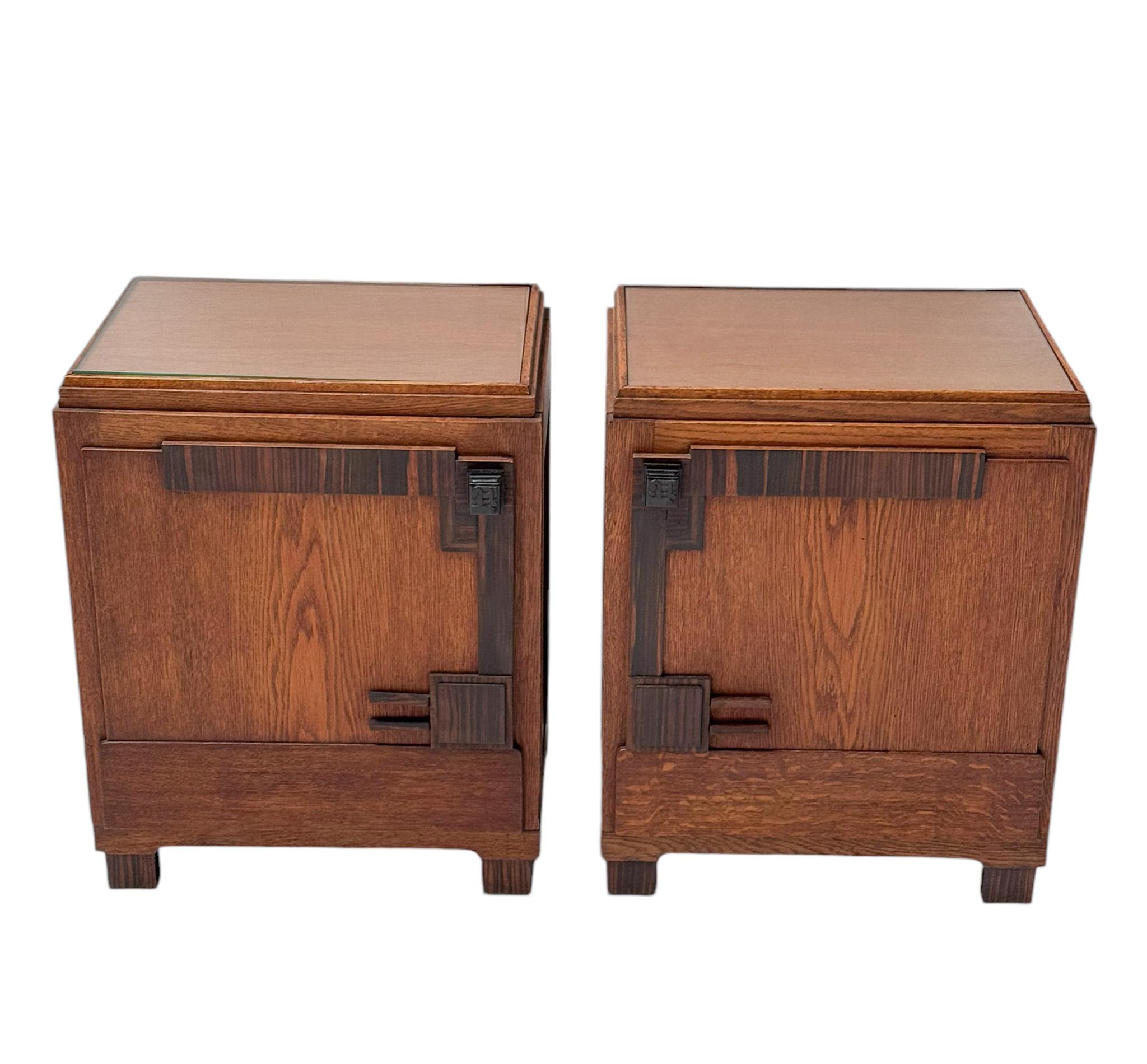 Magnificent and rare pair of Art Deco Amsterdamse School nightstands or bedside tables.
Striking Dutch design from the 1920s.
Solid oak and original oak veneer base with original glass tops.
Original solid macassar ebony knobs on both doors and