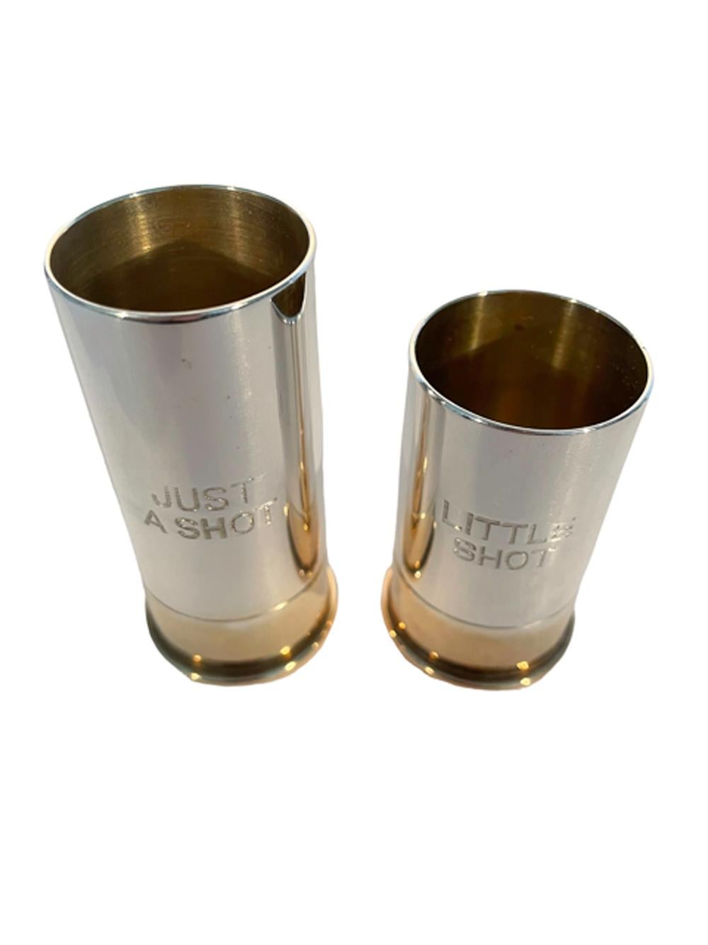 Two Art Deco shotgun shell spirit measures or jiggers in silver plate with gold washed interiors and gold plated bases, engraved 