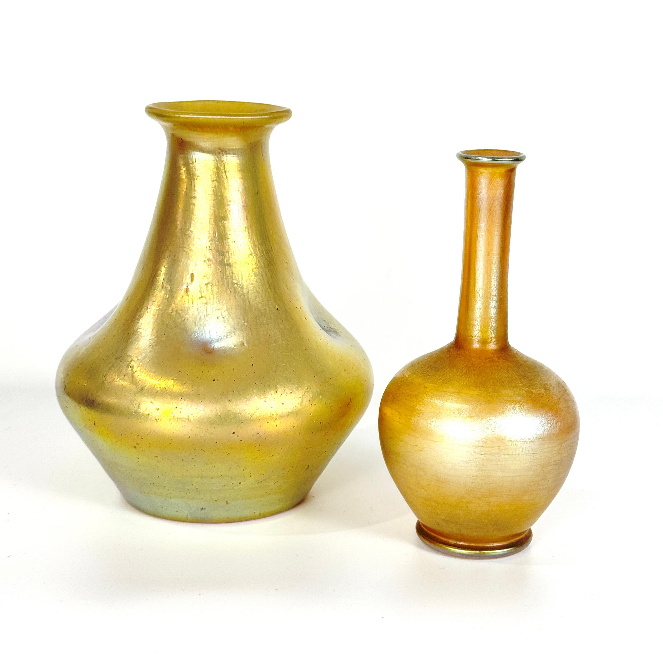 Due vasi in vetro Favrile Art Nouveau in oro iridescente e oro rosa, probabilmente di A.L.C. Tiffany, realizzato all'inizio del XX secolo. Il vaso più grande ha una forma a bottiglia pizzicata, con iridescenza dorata, con la scritta 