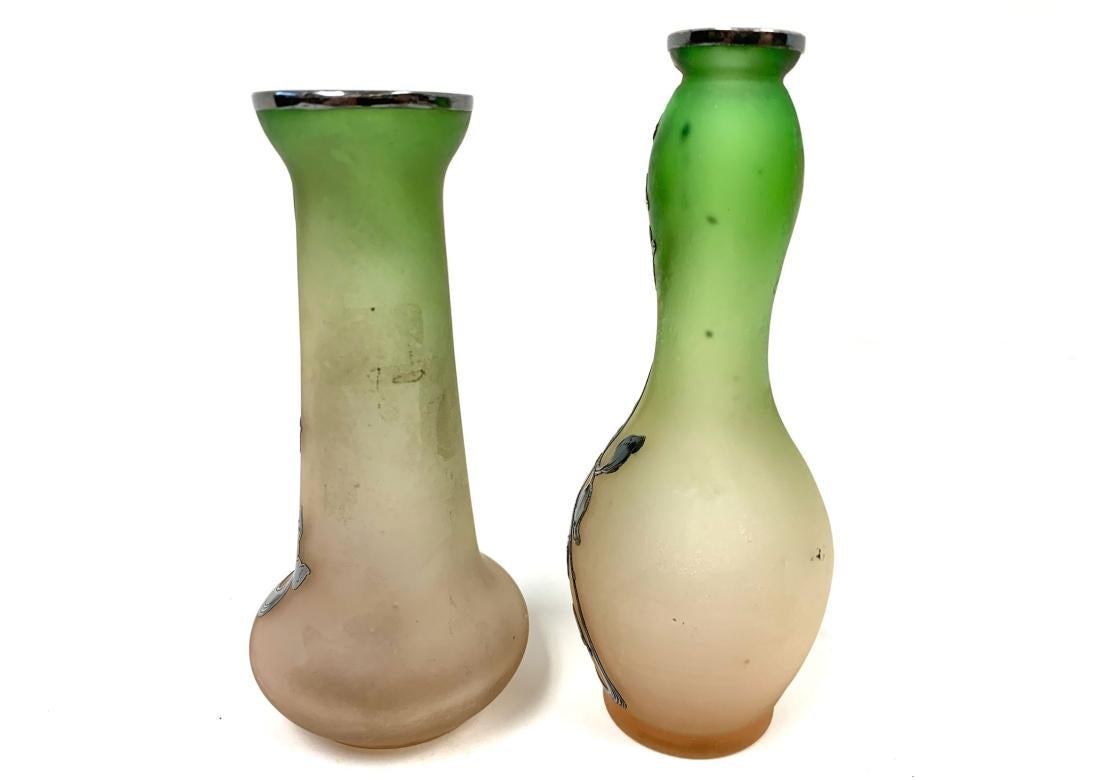 Dos jarrones art nouveau de vidrio esmerilado con diseño floral y borde plateados. El cristal pasa del albaricoque al verde.
Dimensiones: 
Más alto - 5