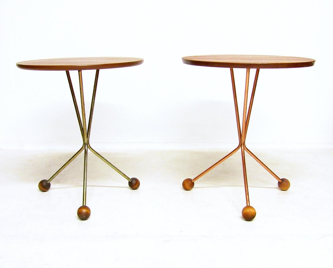 Two 1950s atomic circular teak side tables by Albert Larsson for Alberts Tibro.

Perfect examples of Swedish design, they have atomic wood-tipped legs, one in brass, the other copper.

They are in excellent structural and aesthetic condition.