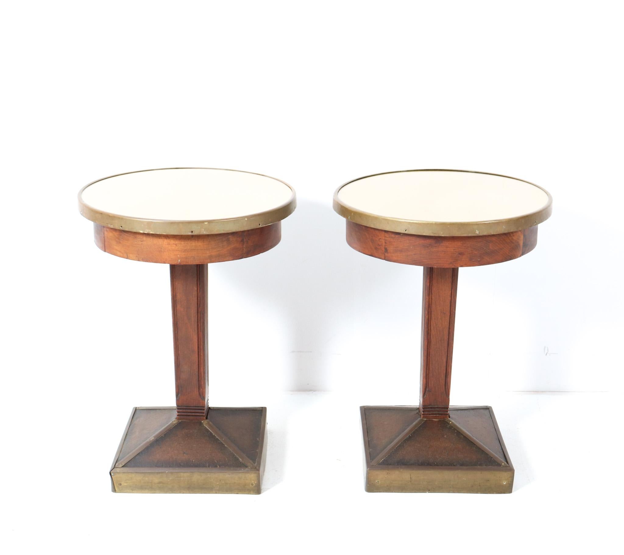 Magnificent and rare pair of Art Deco pub tables or side tables.
Striking French design from the 1930s.
Solid beech frame with original patinated brass elements.
Both tops are renewed with faux leather and glass tops.
This wonderful pair of Art