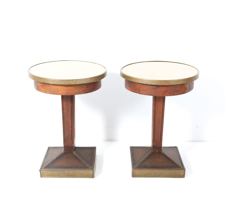 Magnificent and rare pair of Art Deco pub tables or side tables.
Striking French design from the 1930s.
Solid beech frame with original patinated brass elements.
Both tops are renewed with faux leather and glass tops.
This wonderful pair of Art