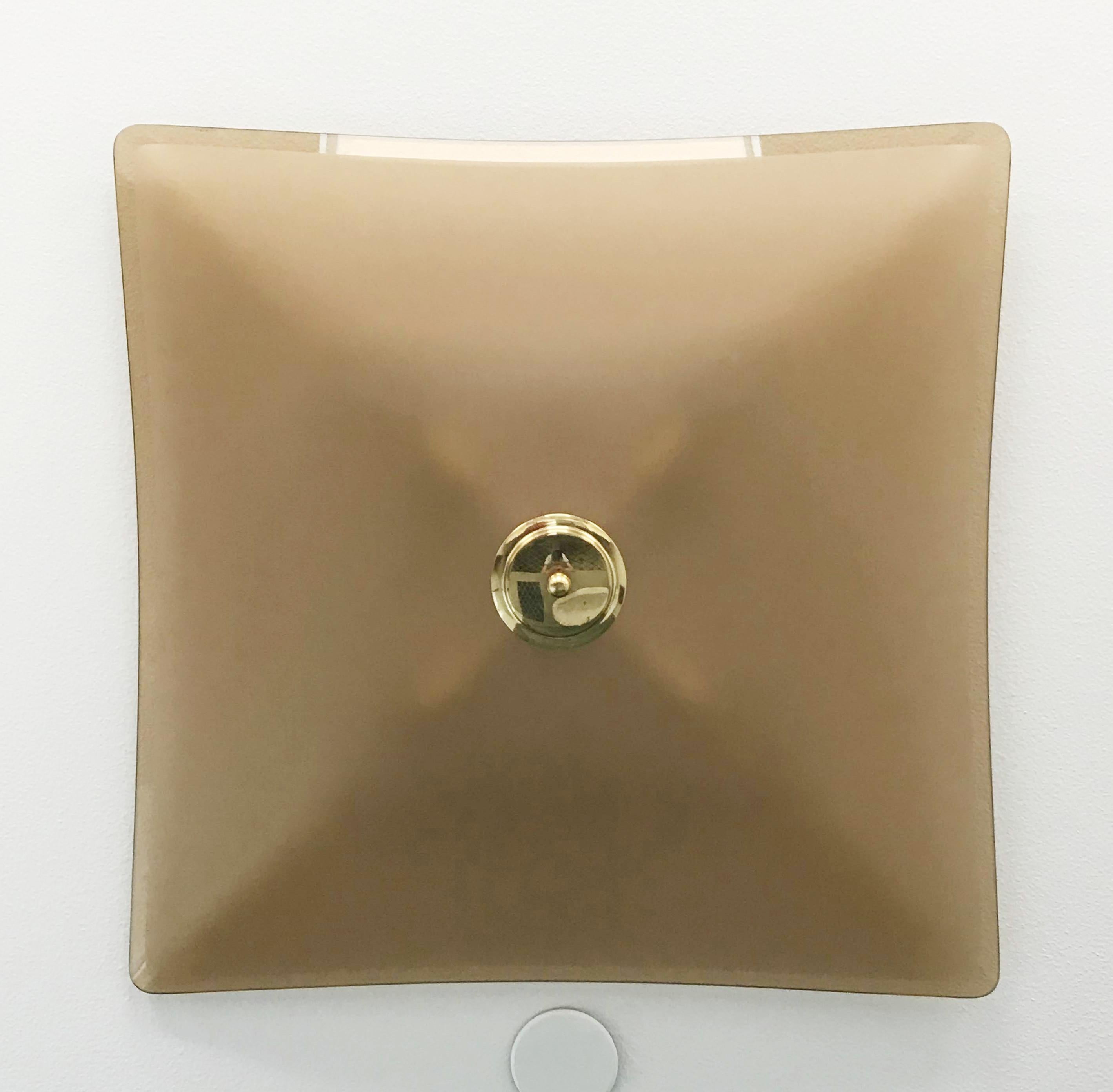 Elegant Italian flush mounts or wall sconces, composed of single smoky colored glass diffusers with beveled edge and satin center, mounted with brass finials on painted white back plates / Made in Italy, circa 1960s.
4 lights / E12 or E14 type / max