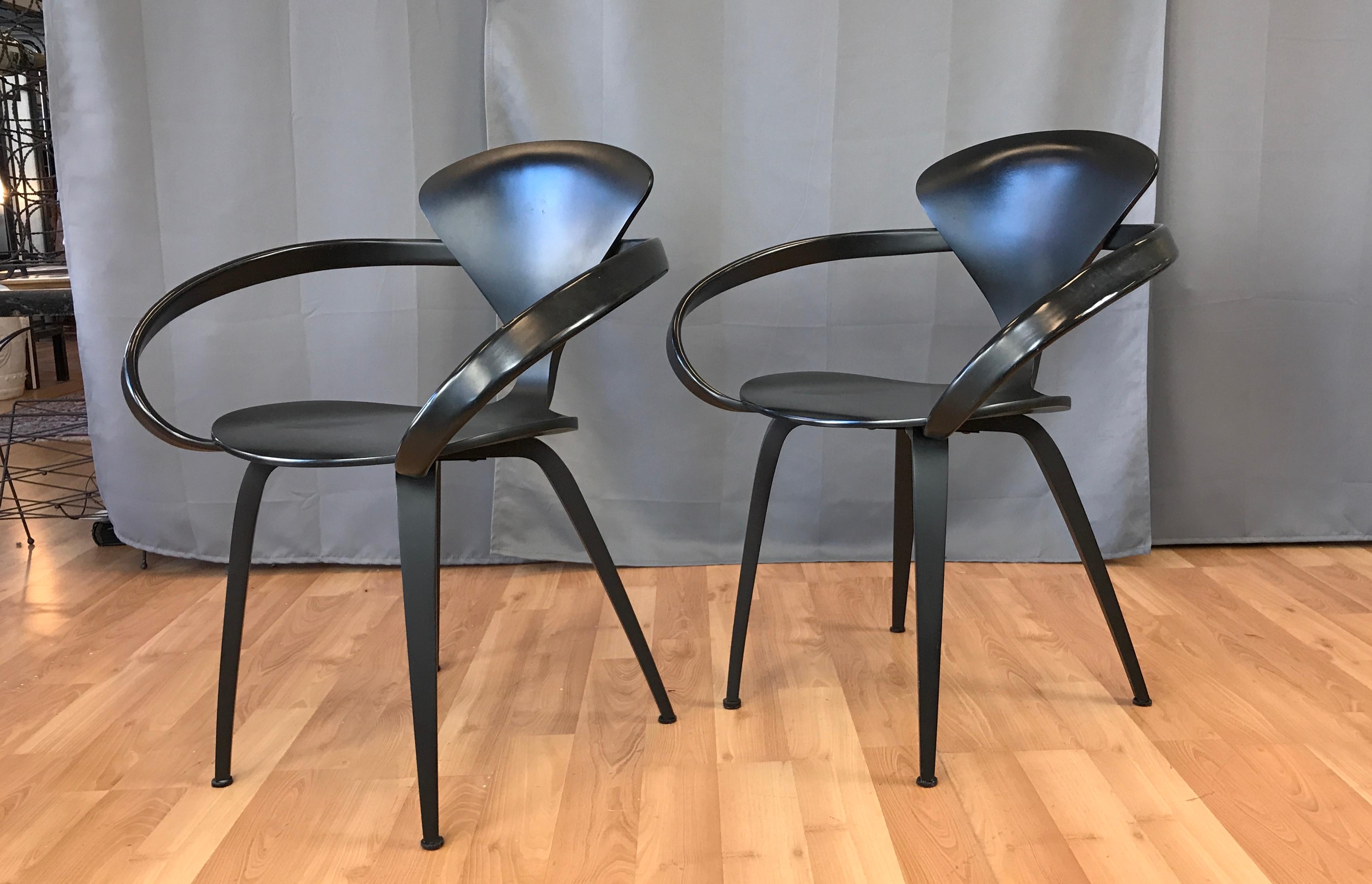 Two black Cherner armchairs designed by Norman Cherner, they were first created for Plycraft. They are now produced by his son's Cherner Chair Company. Constructed of laminated plywood of graduating thicknesses, from 5 ply at the perimeter edge of