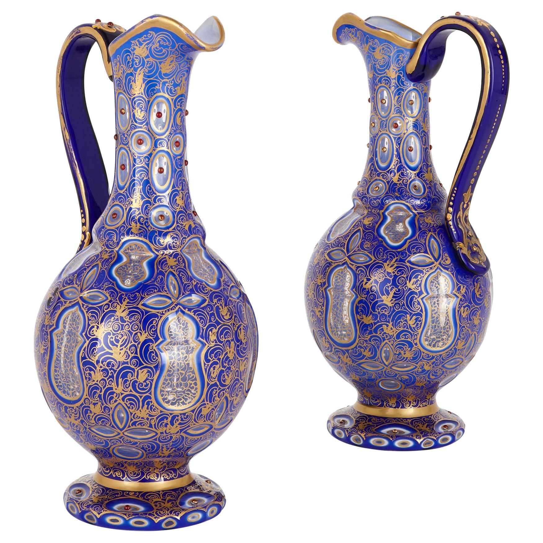 Two Bohemian Persian Style Jeweled and Gilt Blue Glass Jugs