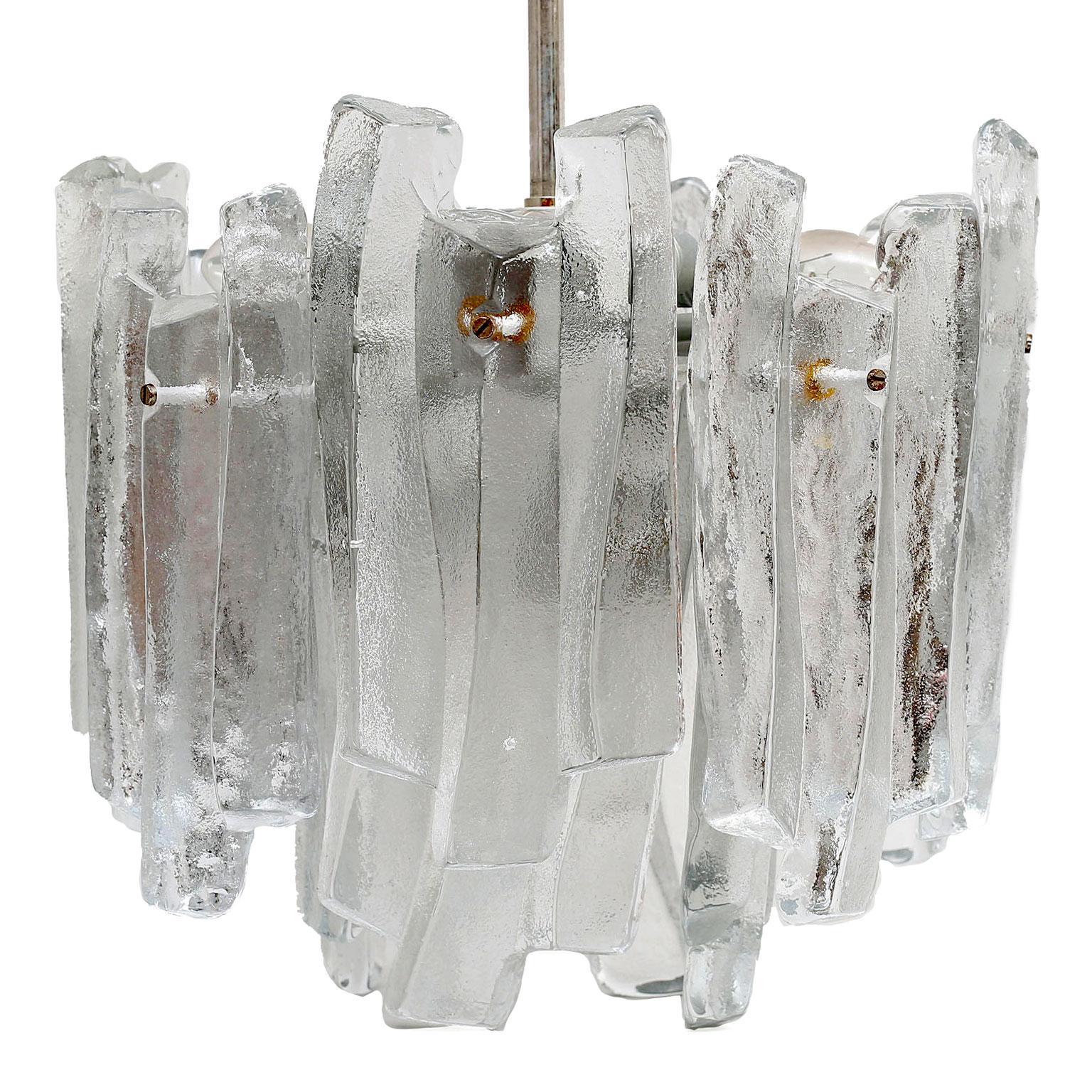 Two bold, chunky brutalist Kalmar KG matte ice glass chandelier with twelve frosted massive glass elements all in perfect condition. A metal frame holding 12 pieces of thick ice looking glass with a matte organically shape, the inside of the glass