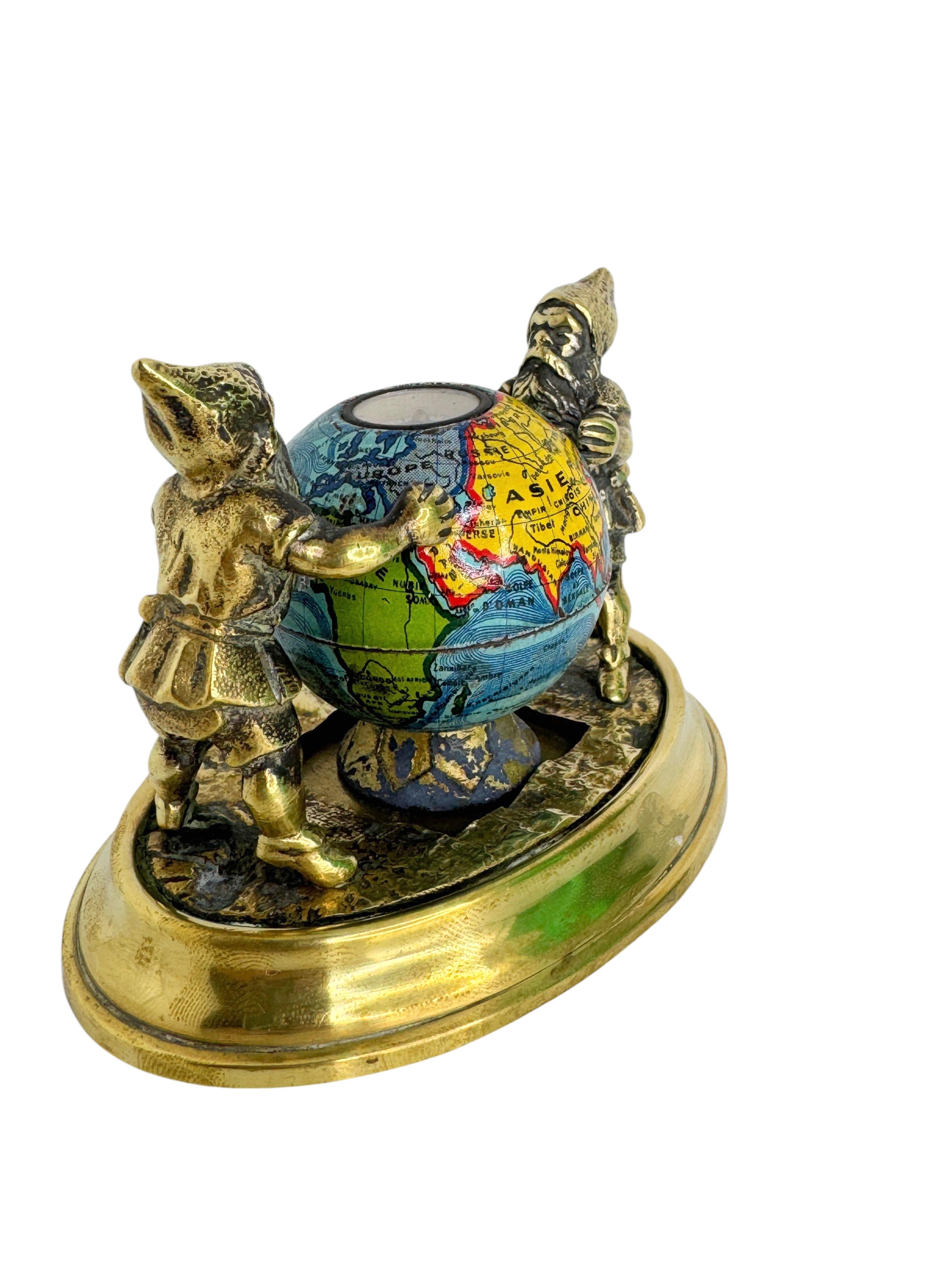 A beautiful bronze Figurine paperweight or desk accessory. Some wear with a nice patina, but this is old-age. Made of bronze and enameled parts. Shows two Gnomes standing on a base with a Globe in the middle. The globe is made of enameled metal and