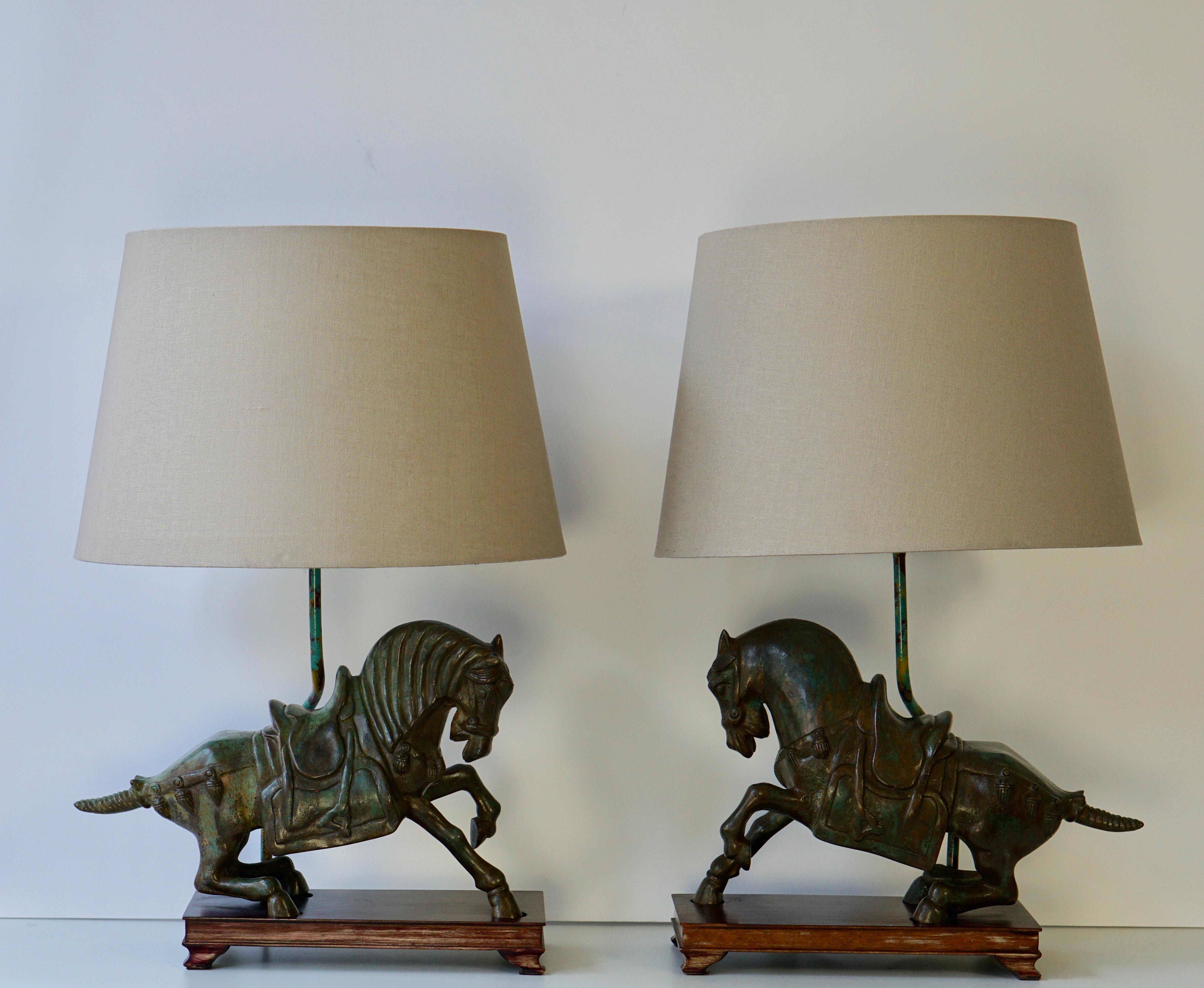 Two bronze horses each in the form of a galloping horse, raised on a wooden plinth and mounted as lamps.
Measures:
Width horse 41 cm, depth 16 cm, height horse 32 cm.
Weight 11 kg.
Height with black shade 67 cm, diameter shade 50 cm.

Shades