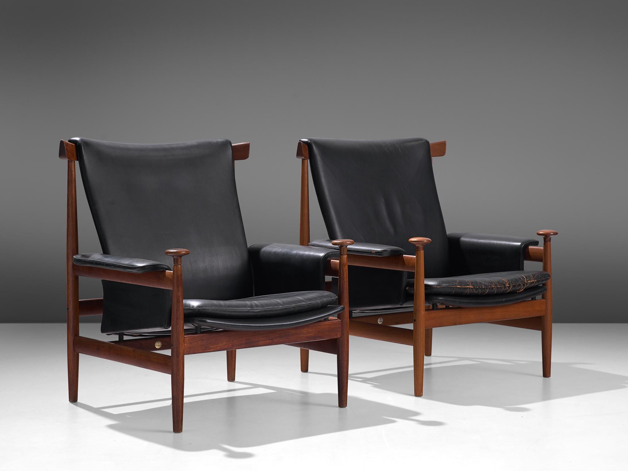 Finn Juhl for France and Son, two 'Bwana' lounge chairs teak and black leatherette, Denmark, 1962 design, 1960s production.

These are two excellent solid teak versions of Finn Juhl's 'Bwana' chair. The 
