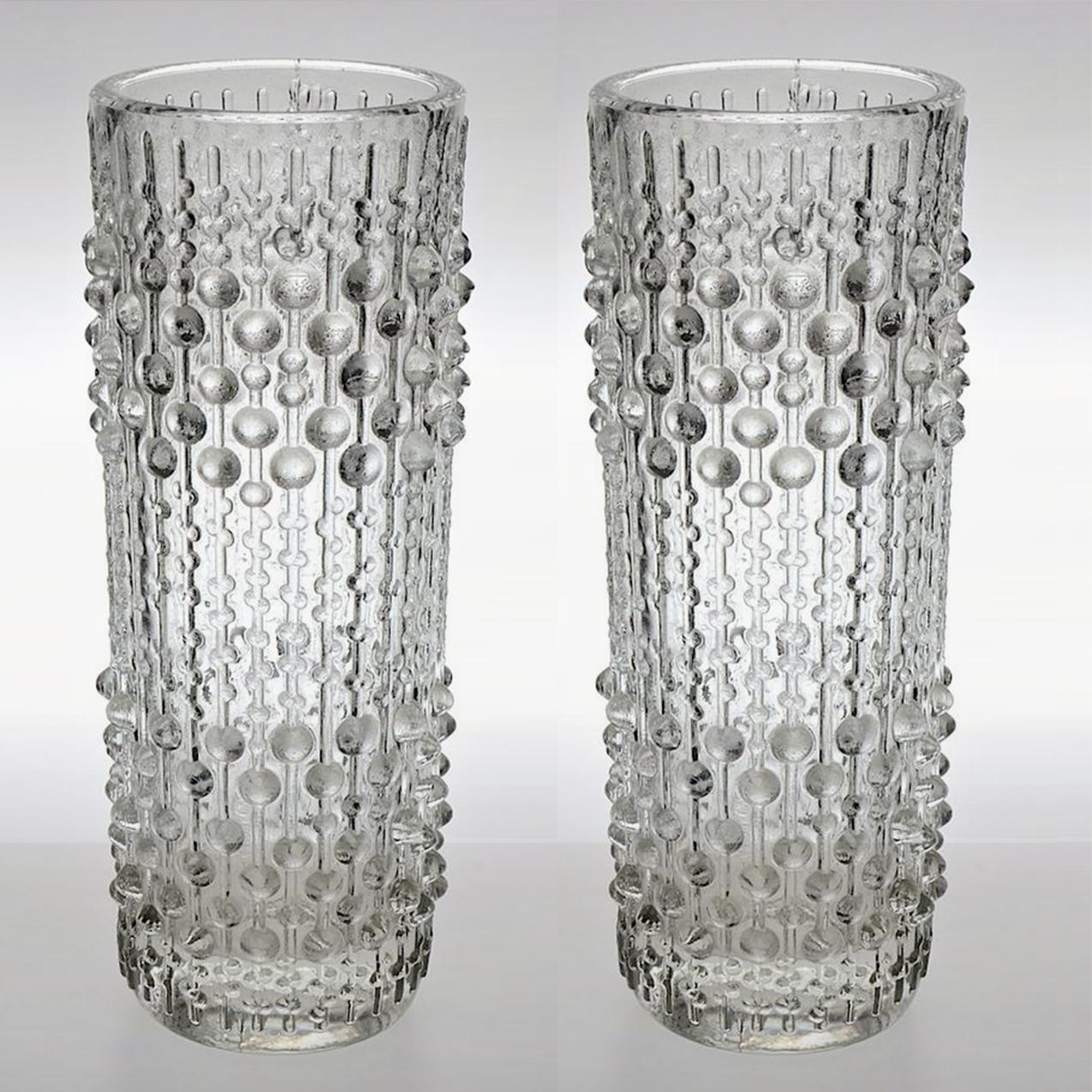 A pair of clear, pressed glass vases/ candleholders for Sklo Union glassworks. The Sklo Union formed in 1965, consisting of a group of Czech glass makers. Illuminates beautifully.

Interesting shape and texture. Called the ‘Candlewax’ design with