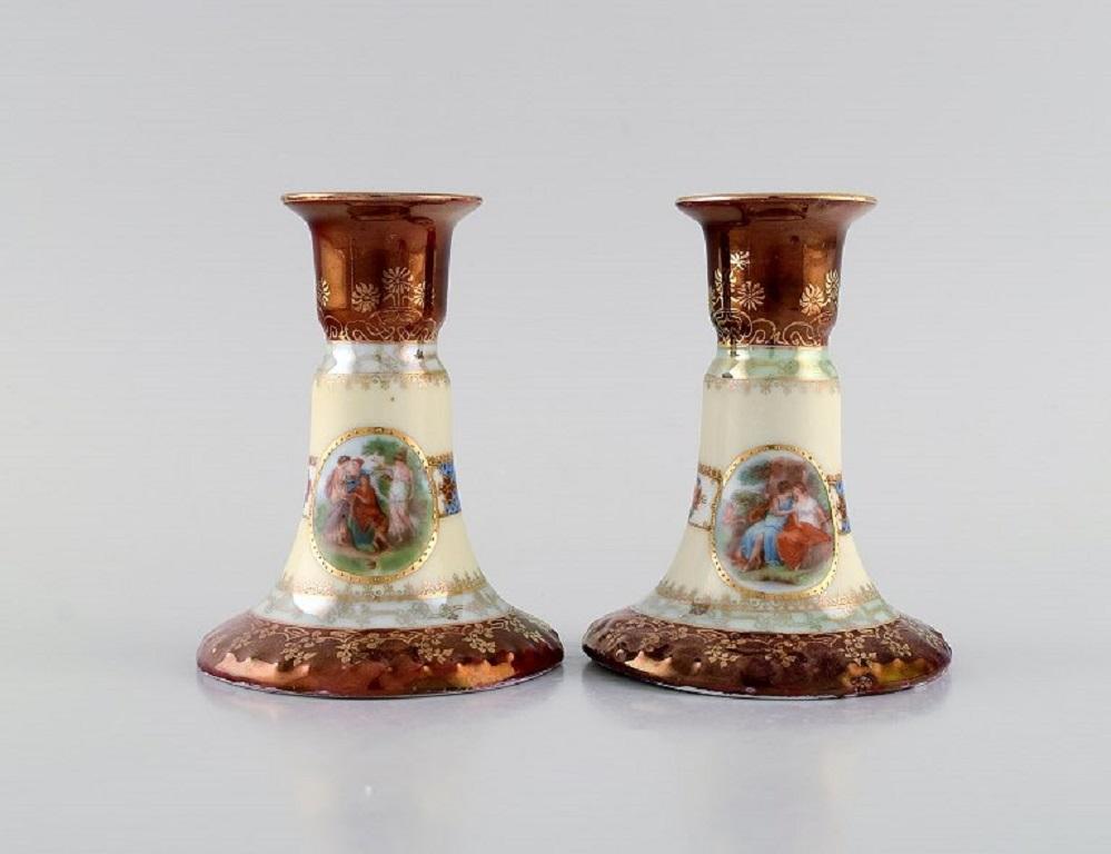 Two candlesticks and ink dryer in hand-painted porcelain. 
Romantic scenes and gold decoration. Vienna, early 20th century.
The candlesticks measure: 11 x 8.5 cm.
Ink dryer measures: 10.5 x 5.5 x 5 cm.
In excellent condition.
Stamped.