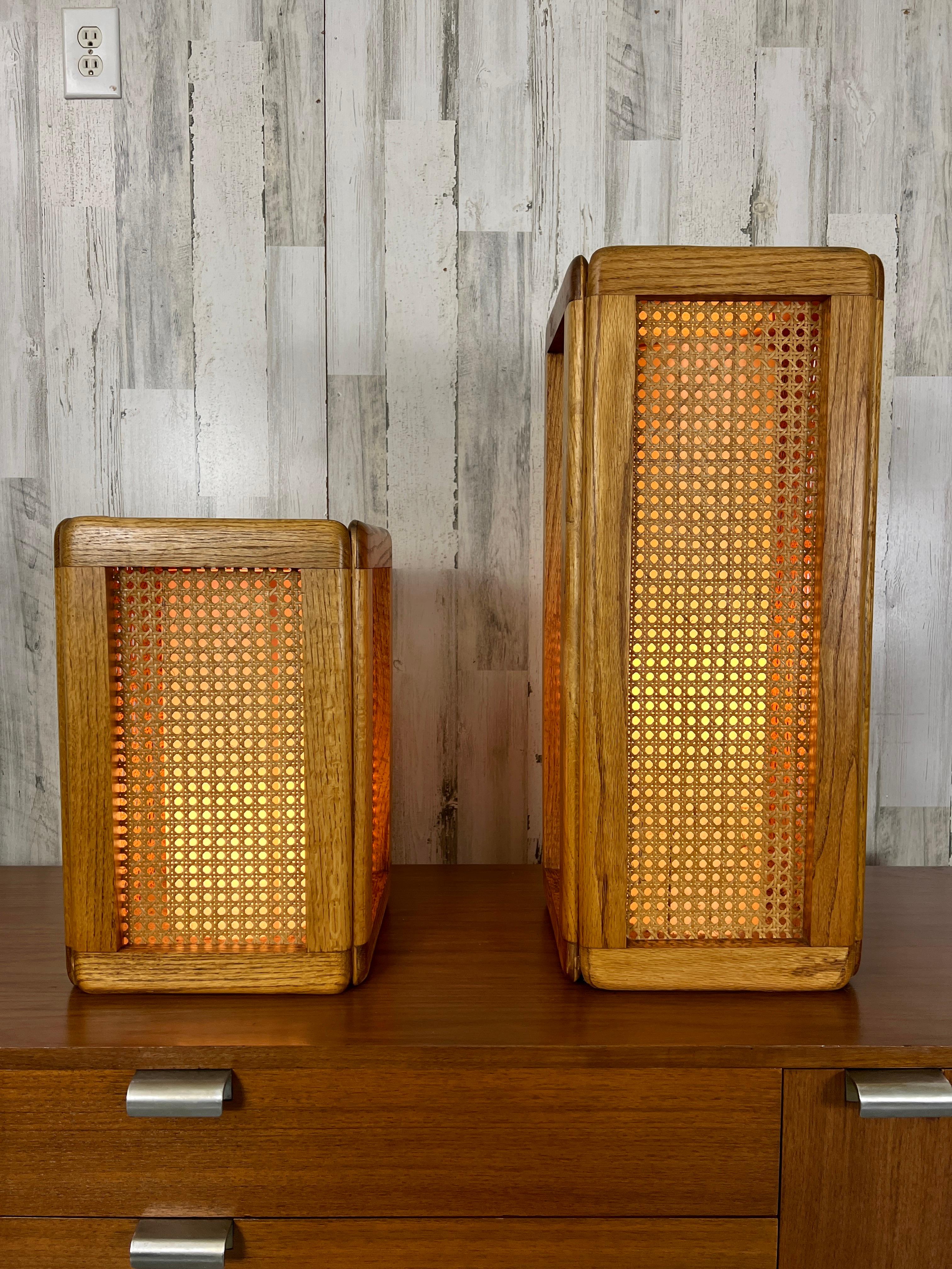 Two Modeline pedestals / table lamps with golden oak frames and cane insert panels. These can be used on the floor as pedestals for art work or as table lamps. The tops are ebonized.


Measurements taller pedestal 10 3/4 by 10 a 3/4 by 26. The