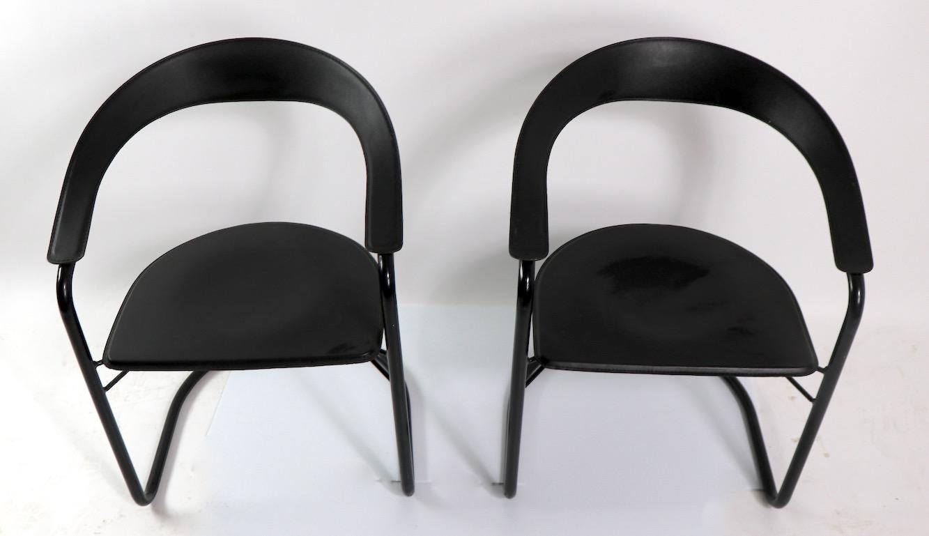 Pair of cantilever design barrel chairs of enameled steel and leather, both marked Made in Italy, attributed to Arrben. Both chairs are in very good original condition, clean and ready to use. Post Modern Art Deco Revival period chairs, stylish,