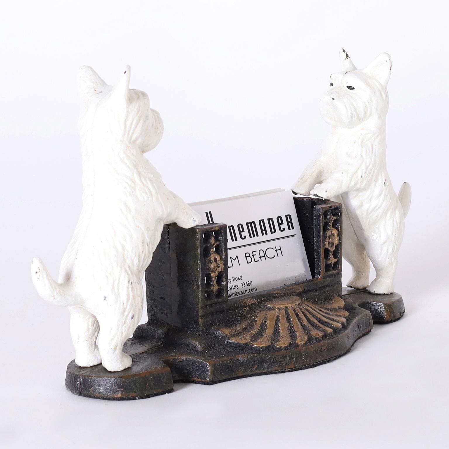 Vintage cast iron card with a pair of Westie terriers in service as greeters.
