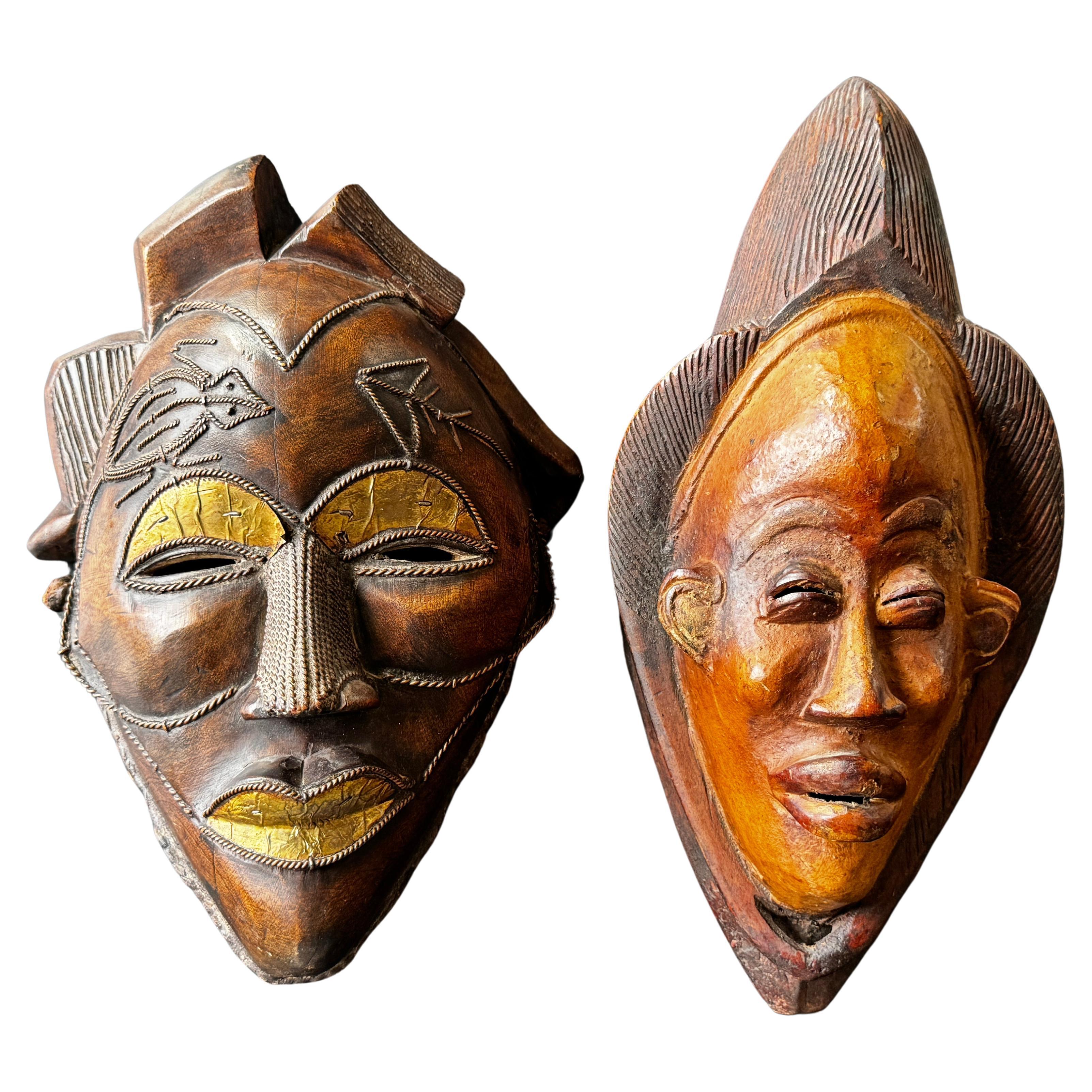 Two Carved Wood African Mask With Gilded Eyelids and Lips and Brass Decorations