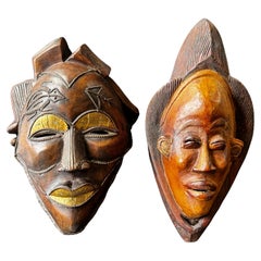 Zwei geschnitzte afrikanische Holzmasken mit vergoldeten Augenlidern und Lips und Messingdekorationen