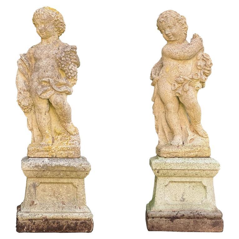 Due cherubini in pietra fusa su plinti dai giardini botanici del Bronx in vendita