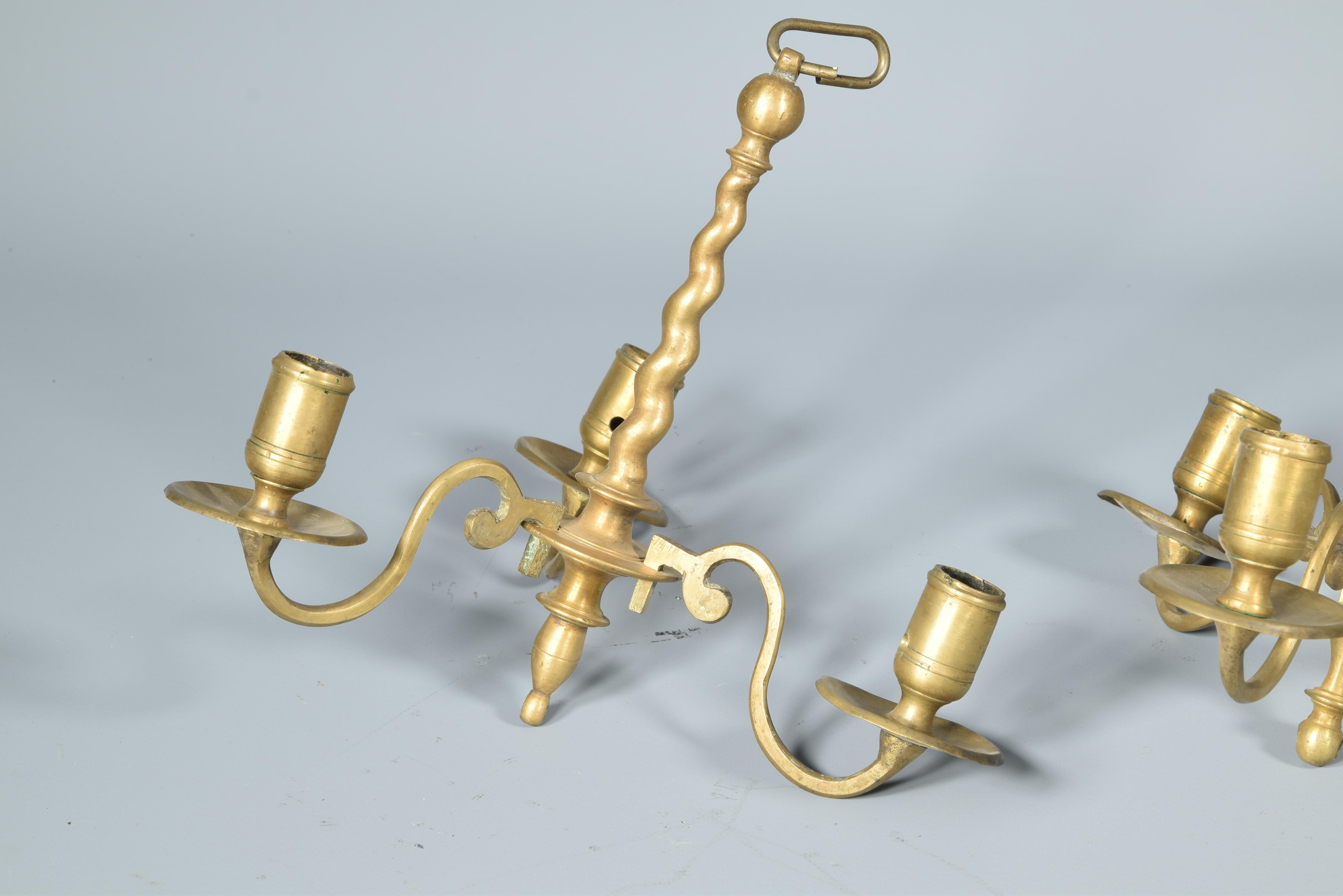 Two votive lamps, bronze, 18th century.
Bronze ceiling lamps with three lights each. One of them has an axis ballasted with discs and spheres from which split the three flat curved arms that end in pieces for the candles. The other has a spiral