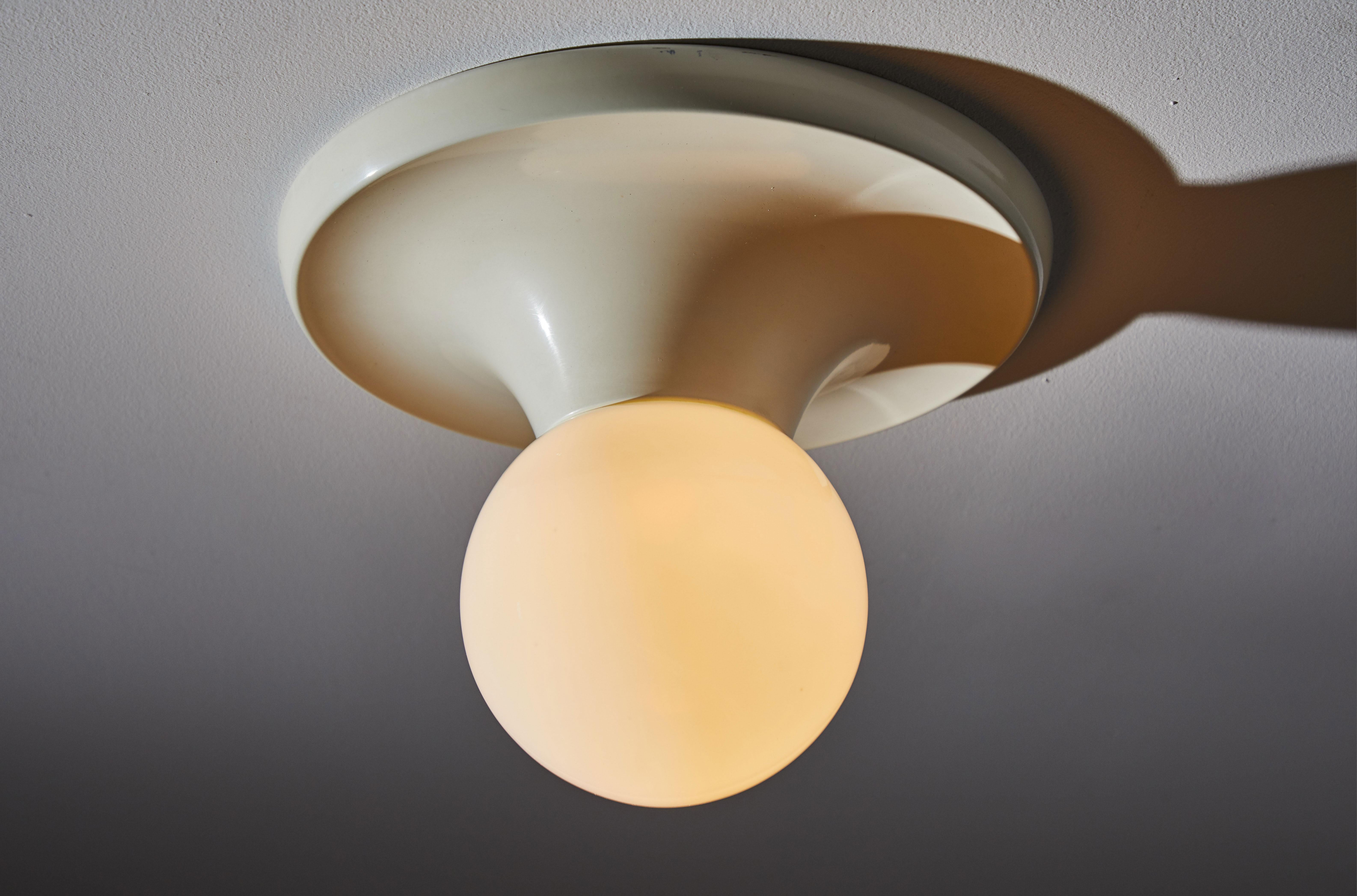 Two ceiling lights by Achille Castiglioni. Designed and manufactured in Italy for Flos, circa 1960s. Enameled metal and opaline glass. Rewired for US junction boxes. Each light takes one E26 75w maximum bulb. Priced and sold individually.