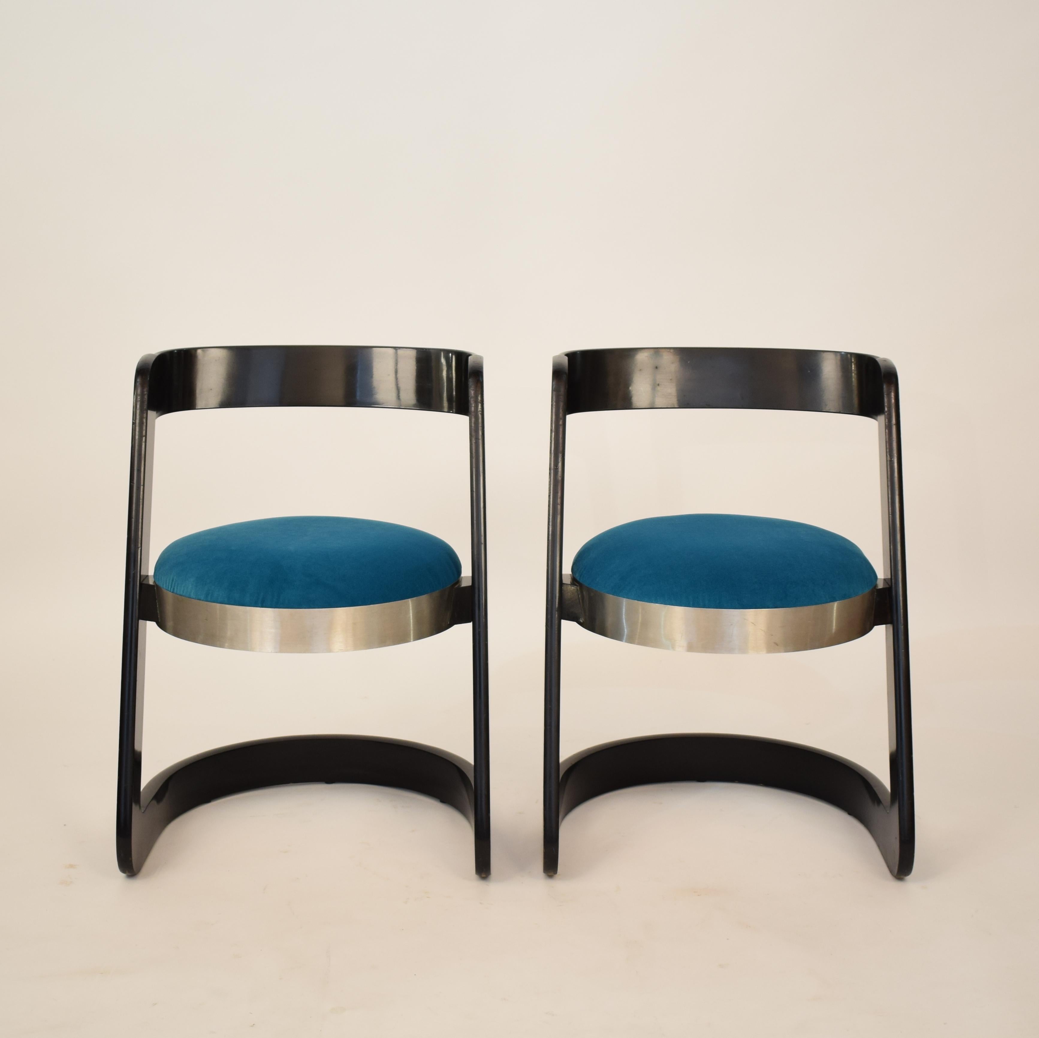 Those two beautiful midcentury or Space Age chairs where designed in 1970 by Willy Rizzo for Mario Sabot.
They are in black lacquered wood with aluminum and the seat upholstery is in turquoise velvet.
The chairs are one of Rizzo most important