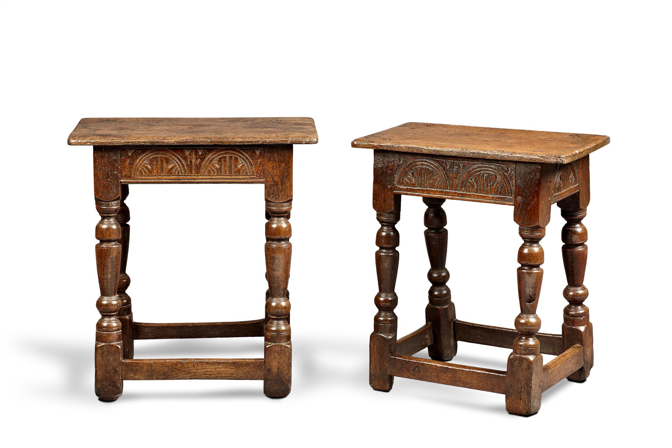 Near pair of Charles I oak and elm joined stools Gloucestershire, circa 1630-1640.

The moulded plank tops above tapered baluster and cup and cover turned legs joined by lunette carved Elm frieze rails, with plain stretchers. 

Two virtually