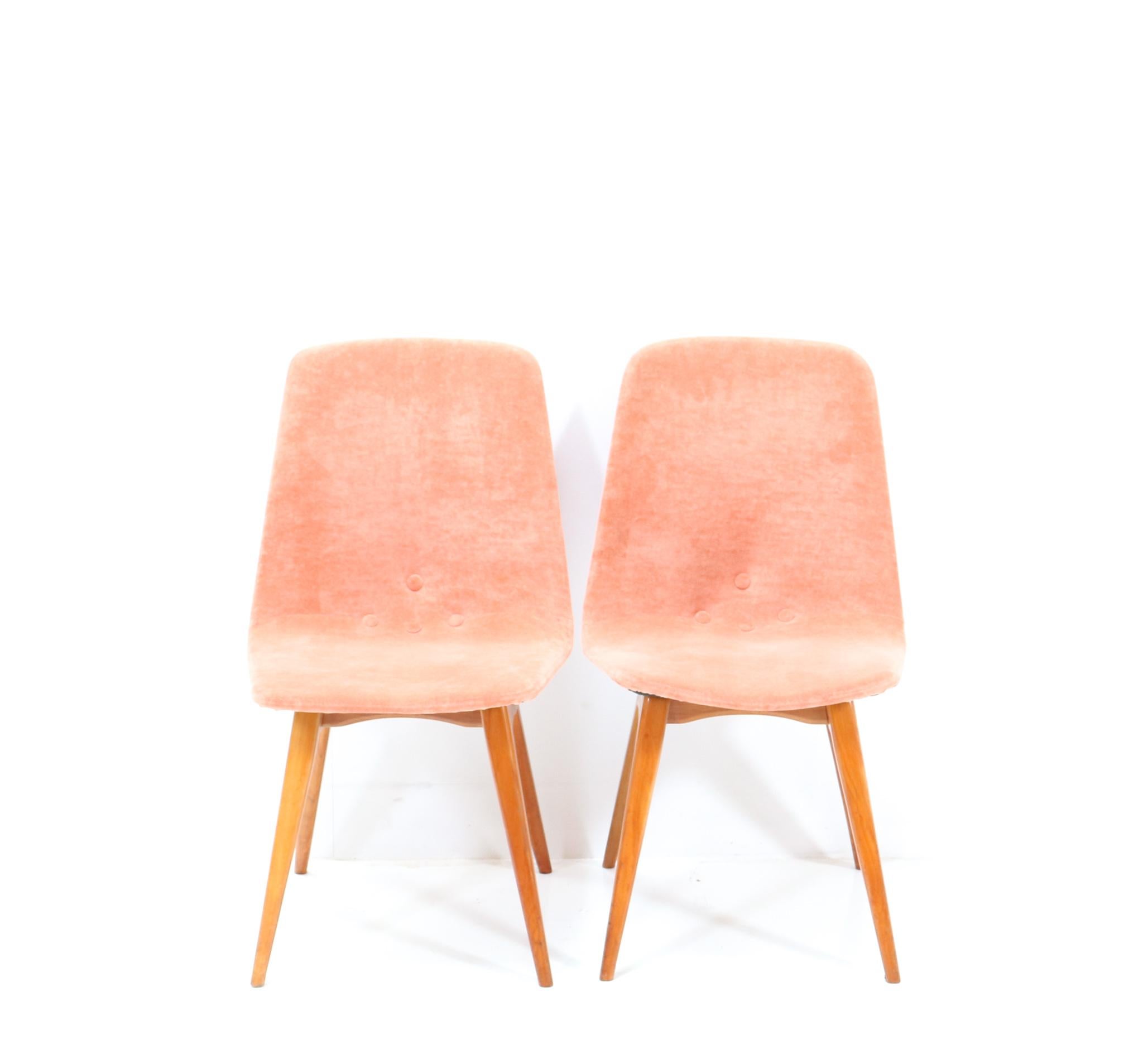 Stunning set of two Mid-Century Modern Model Swing dining room chairs.
Design by G. Van Os for Meubelfabriek G.J. Van Os N.V. Culemborg.
Striking Dutch design from the 1950s.
Solid cherry frame with later salmon velvet upholstery.
Amazing design