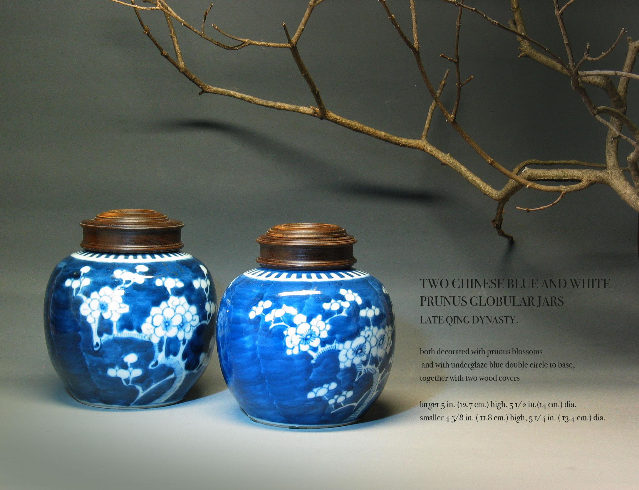 Two Chinese blue and white Prunus Globular Jars, late Qing dynasty, both decorated with prunus blossoms and with underglaze, blue double circle to base, together with two wood covers. The larger of the vases measures 5