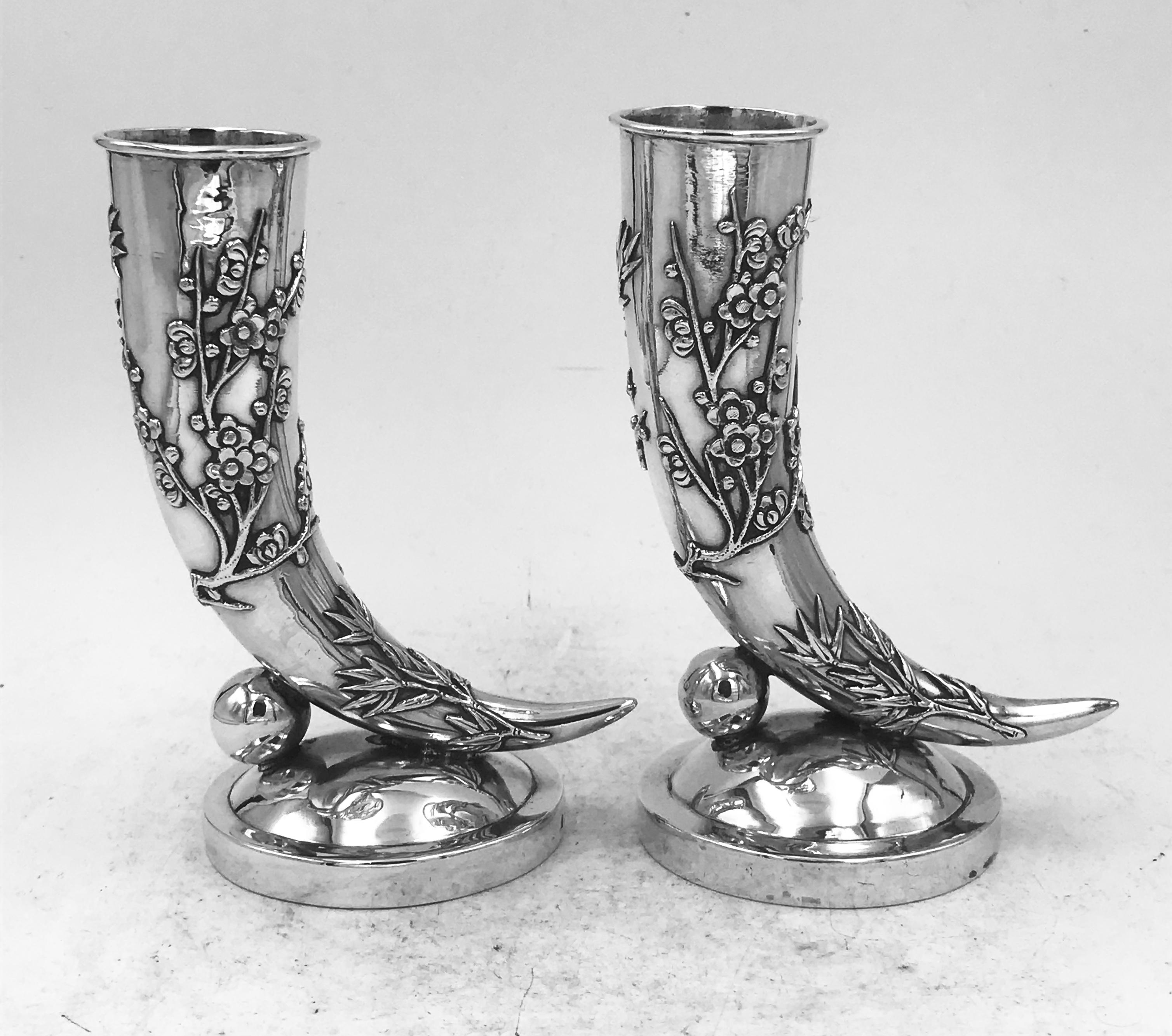 Zwei chinesische Silbervasen in Form eines Füllhorns, beide mit aufgelegtem Bambus und Chrysanthemen verziert und auf einem runden Sockel. Die Vasen sind ähnlich, wurden aber von verschiedenen Silberschmieden hergestellt und von verschiedenen