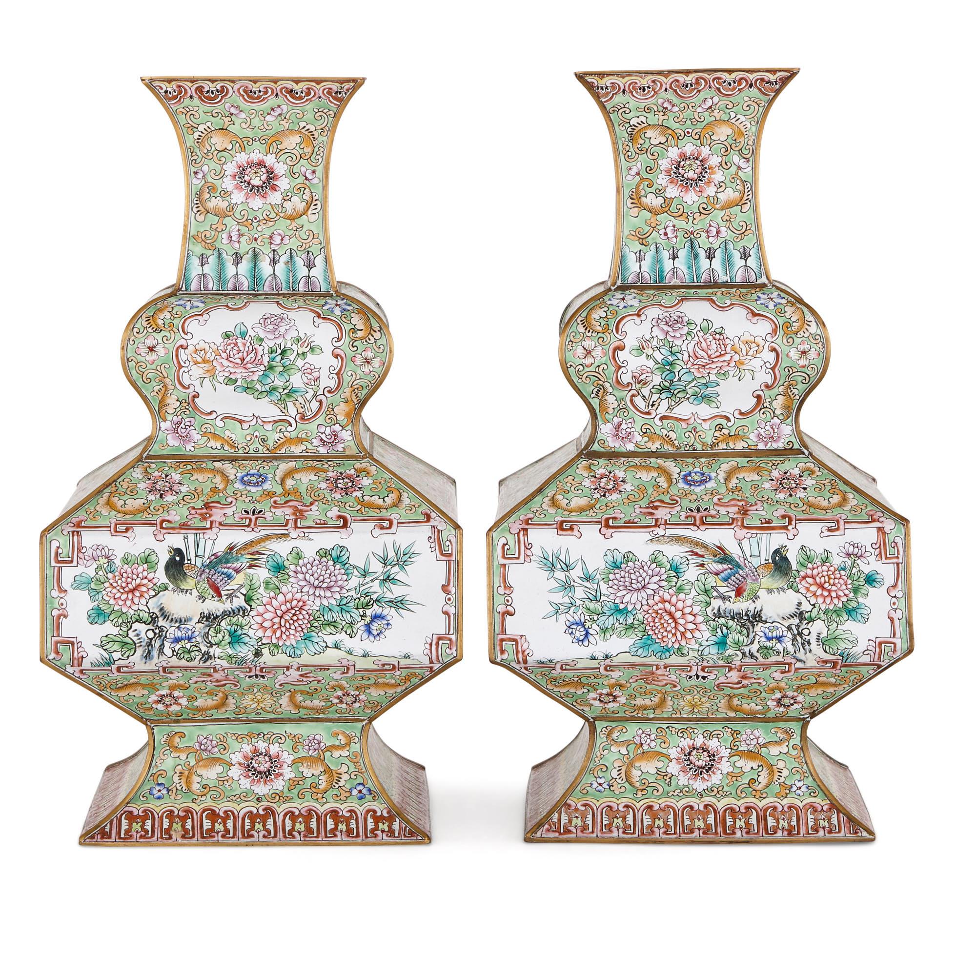 These elegant vases were created in the early 20th century, in the last decade of the Qing dynasty (1644-1911). They are covered with beautiful cloisonné enamel designs. In the cloisonné method, strips of metal are applied to the surface of an