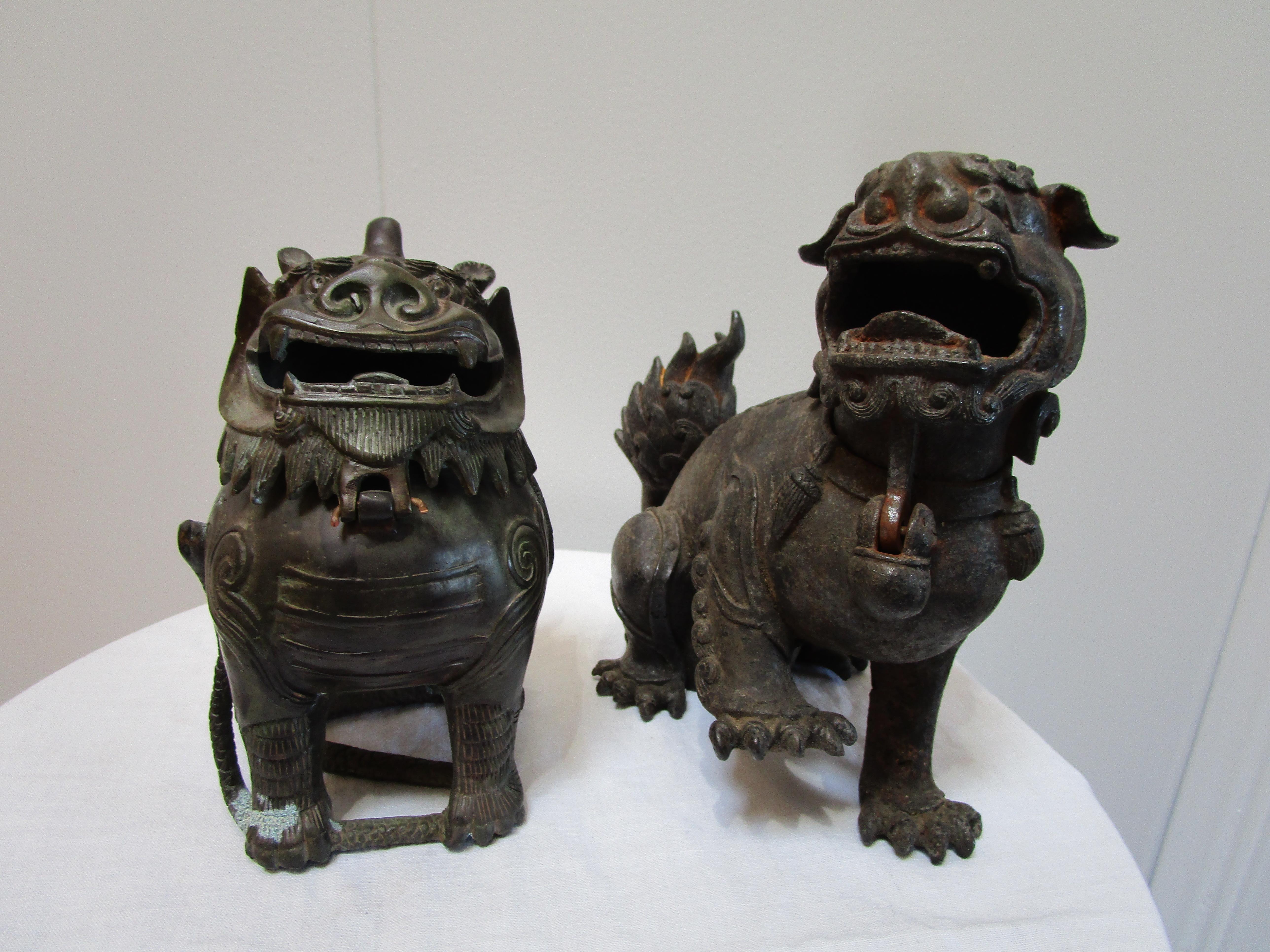 Two Asiatic Lions -- foo dogs protect the premises in an assembled pair. The smaller female lion stands on the body of a dragon that is trapped at her sides. She has a mark with the maker's signature and the year of production. She stands at 5.5