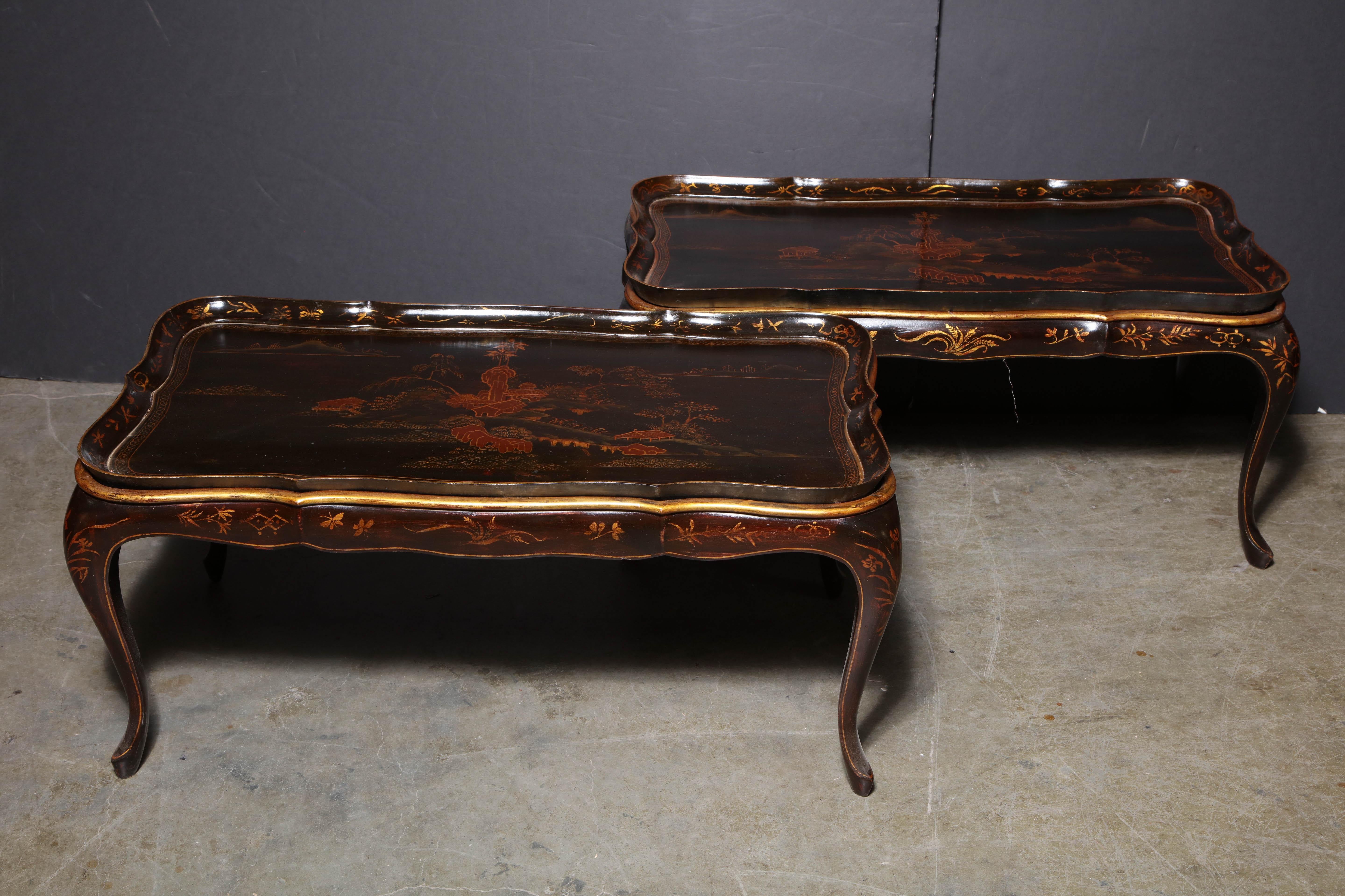 Two black lacquered Chinese low tables with serpentine (removable) tray tops on cabriole legs.