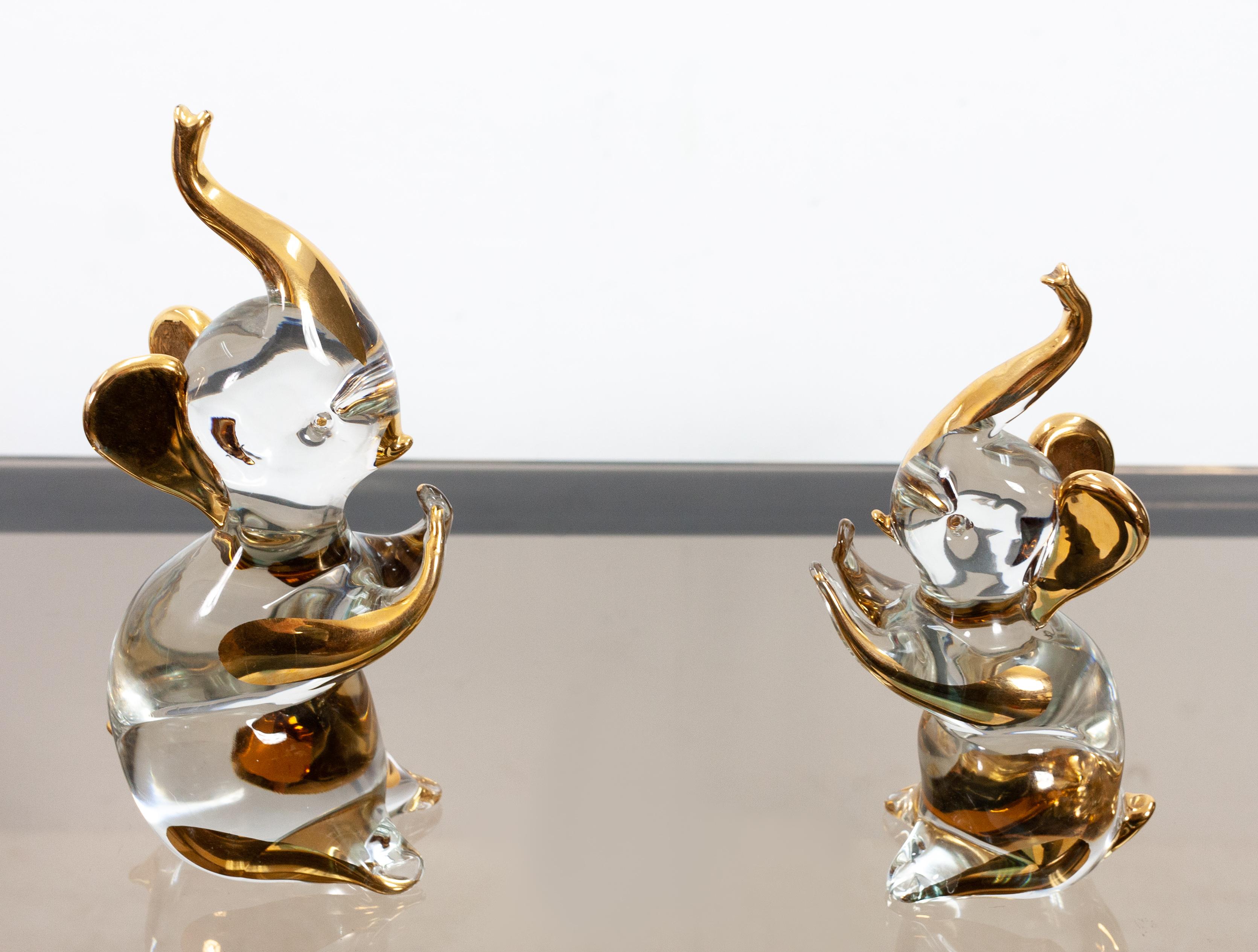 Two adorable little Elephants. Made by Murano 1980. Hollywood Regency style.
Chrystal glass with 24-carat gold. Very nice bookends. Excellent condition.

Smaller one height 19 cm, width 6 cm, depth 8 cm
Larger one height 22 cm, width 7 cm, depth