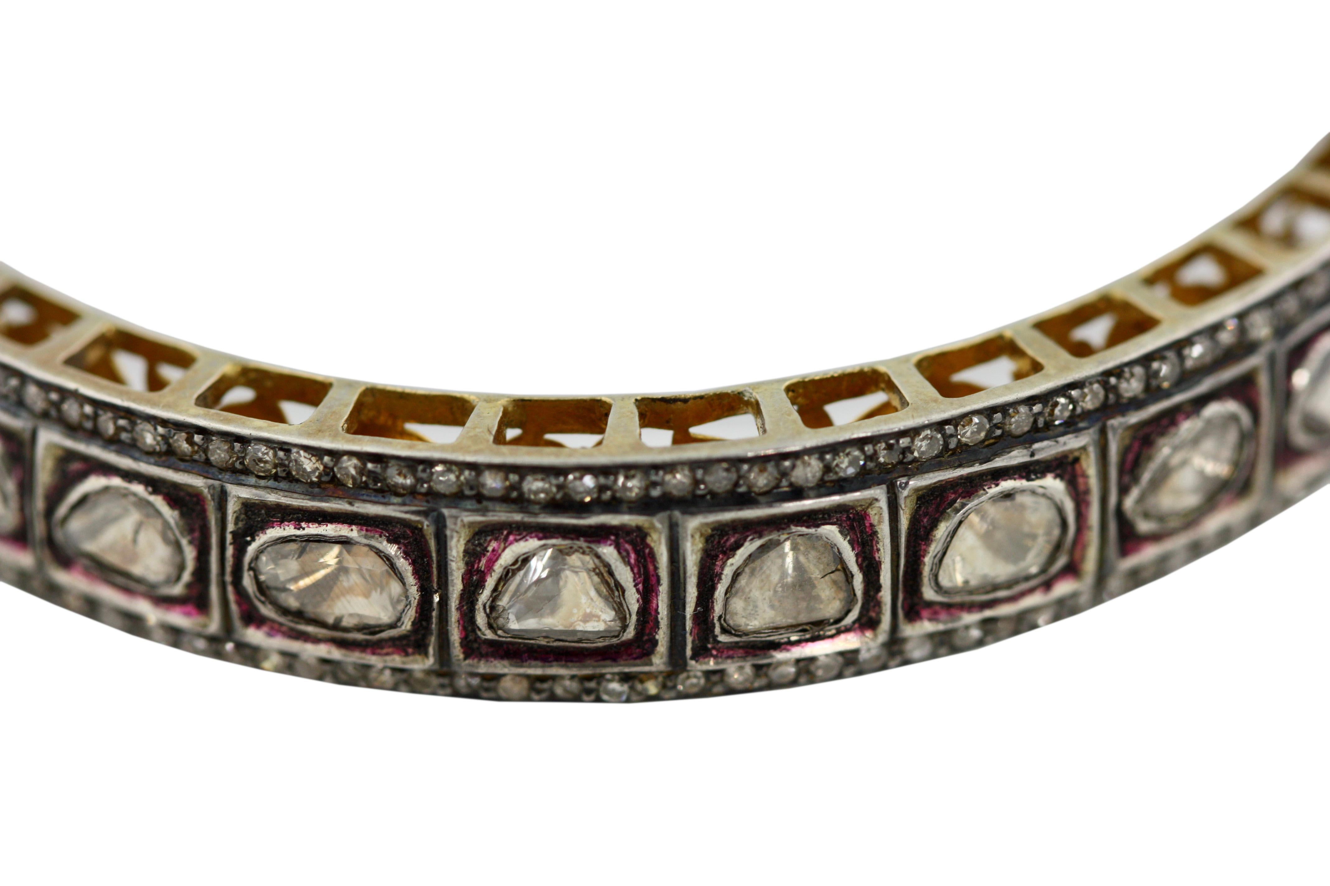 TWO-COLOR GOLD AND DIAMOND BANGLE-BRACELET
Of hinged design, the openwork floral lattice set with rose cut diamonds, bordered by round cut diamonds, gross weight approximately 43 grams, internal circumference 4.5 inches (11.43 cm.)