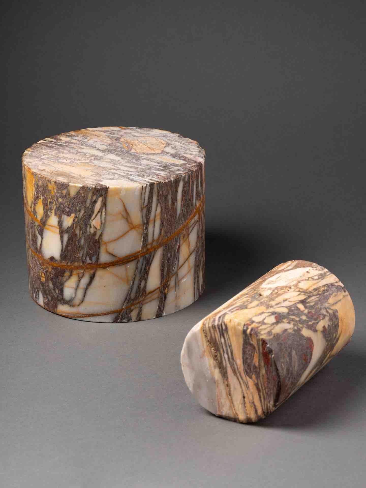 Zwei zylindrische Exemplare aus Breccia Skyros Marmor oder Settebassi

Diese beiden zylindrischen Exemplare eignen sich hervorragend als Buchstützen oder als Geschenk für Kunstwerke. 
Der Name stammt von dem Stein, der in der Antike auf der Insel