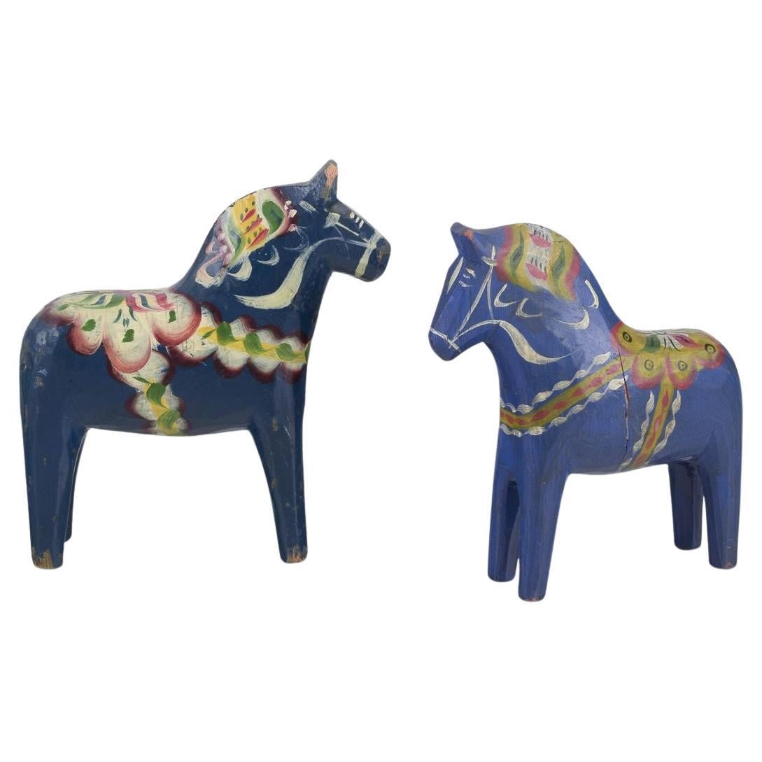 Dos caballos Dala. Pintada a mano con motivos florales sobre fondo azul. Arte popular.
