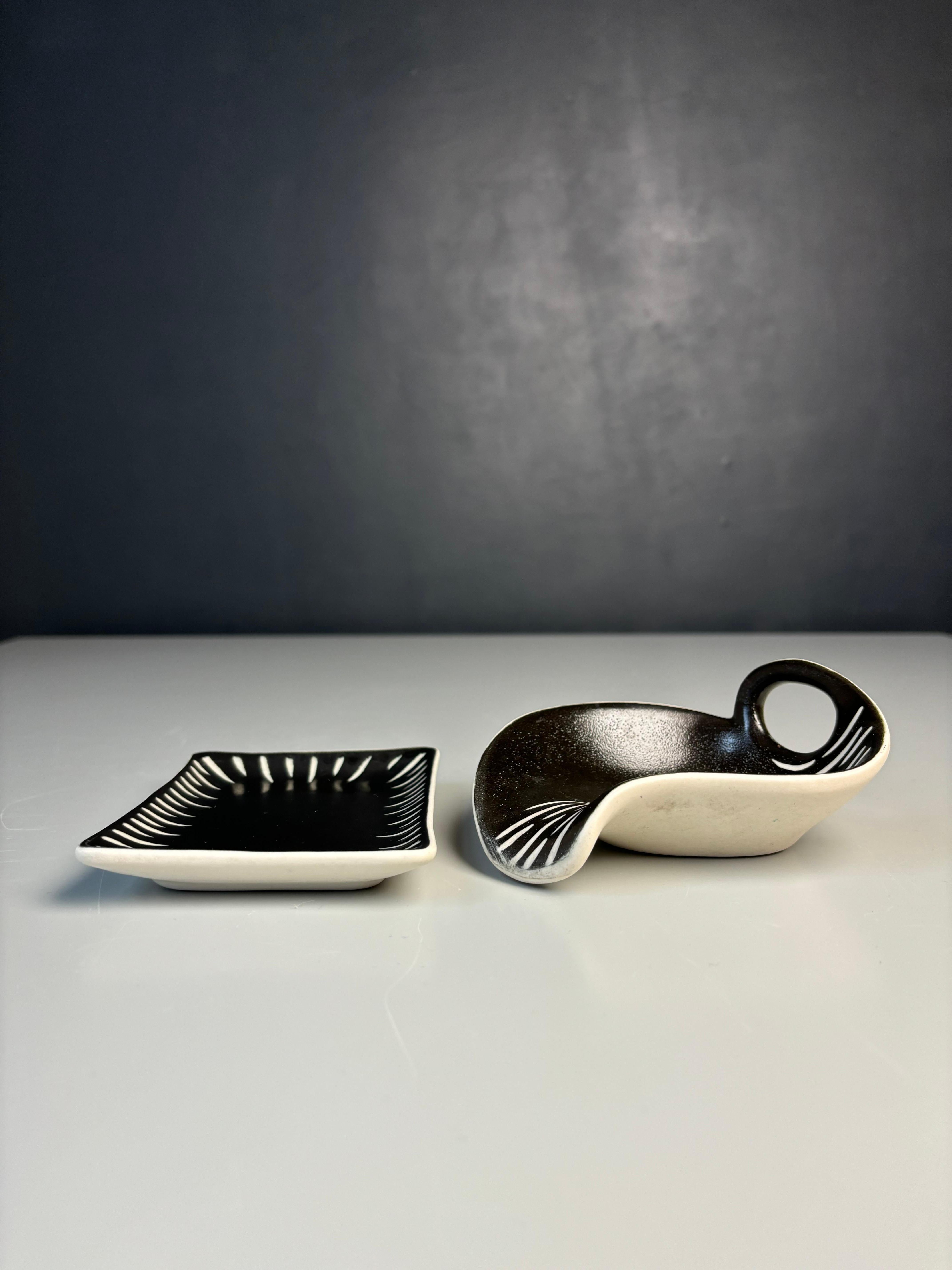 Set di due videopoche decorative danesi della metà del secolo scorso, di colore nero lucido e con decorazioni bianche incise, disegnate e realizzate a mano dall'artista ceramista Aksel Sigvald Nielsen per Aksini Keramik negli anni '60. Una ciotola
