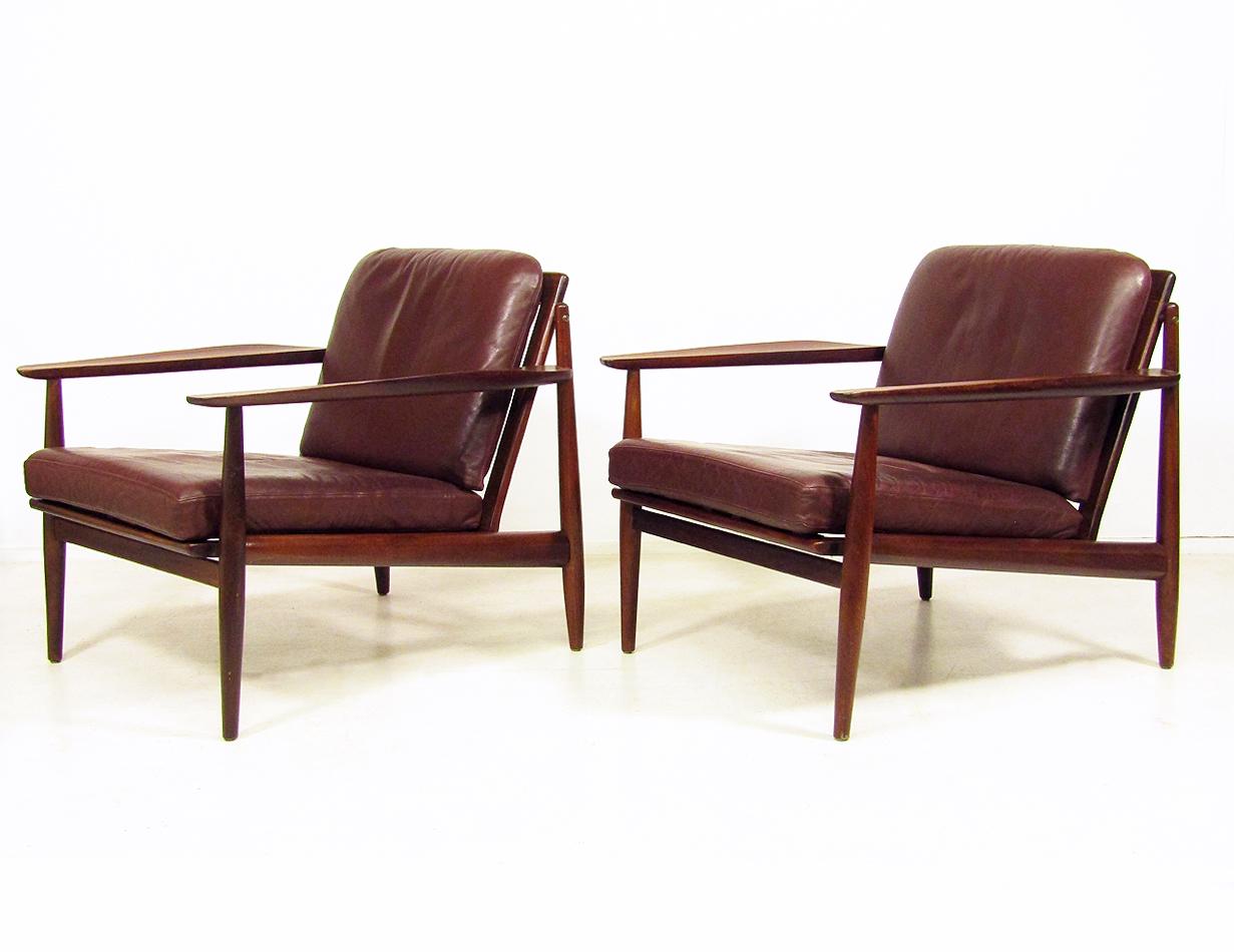 A pair of beautiful, early 1960s lounge chairs by Arne Vodder for Glostrup.

In rare mahogany with brass detail and original chocolate-colored leather cushions, they create a strong, streamlined impression.

The sculpted arms have particularly