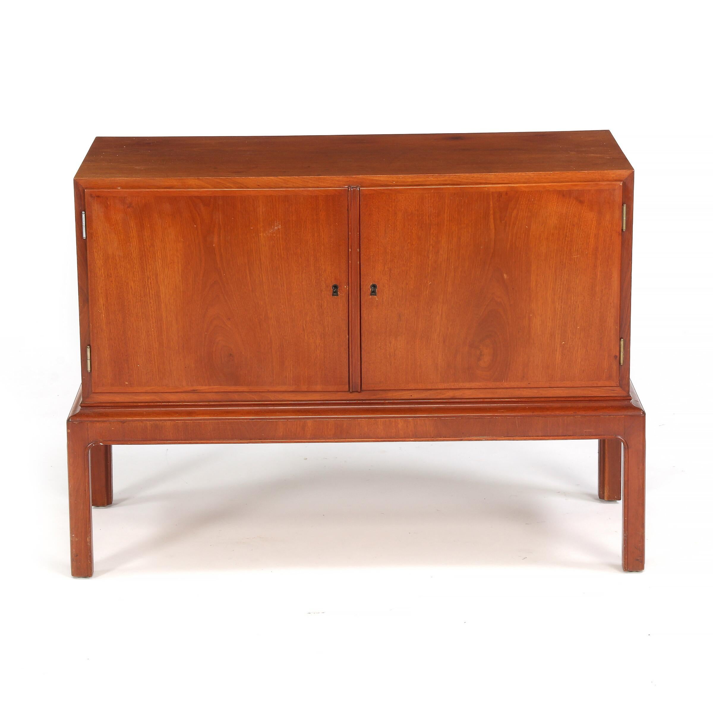 Two high quality Danish modern cabinetmaker sideboards, in rich medium brown mahogany, each with two doors, and shelving, one with three drawers. Measures: H. 31