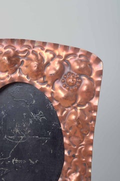 Two decorative picture frames in embossed copper with floral motifs.