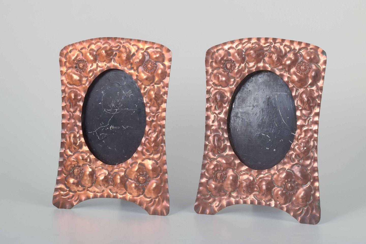 Two decorative picture frames in embossed copper with floral motifs.