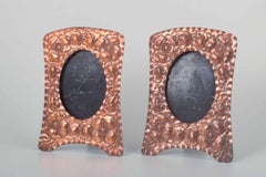 Two decorative picture frames in embossed copper with floral motifs.